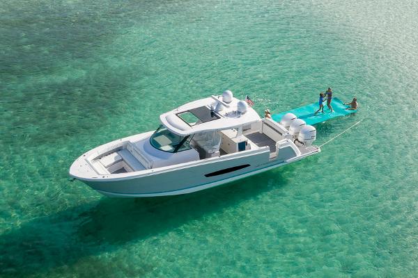 Manufacturer Provided Image: 2026 Regal 38 SAV yacht on clear turquoise water with people enjoying water activities.