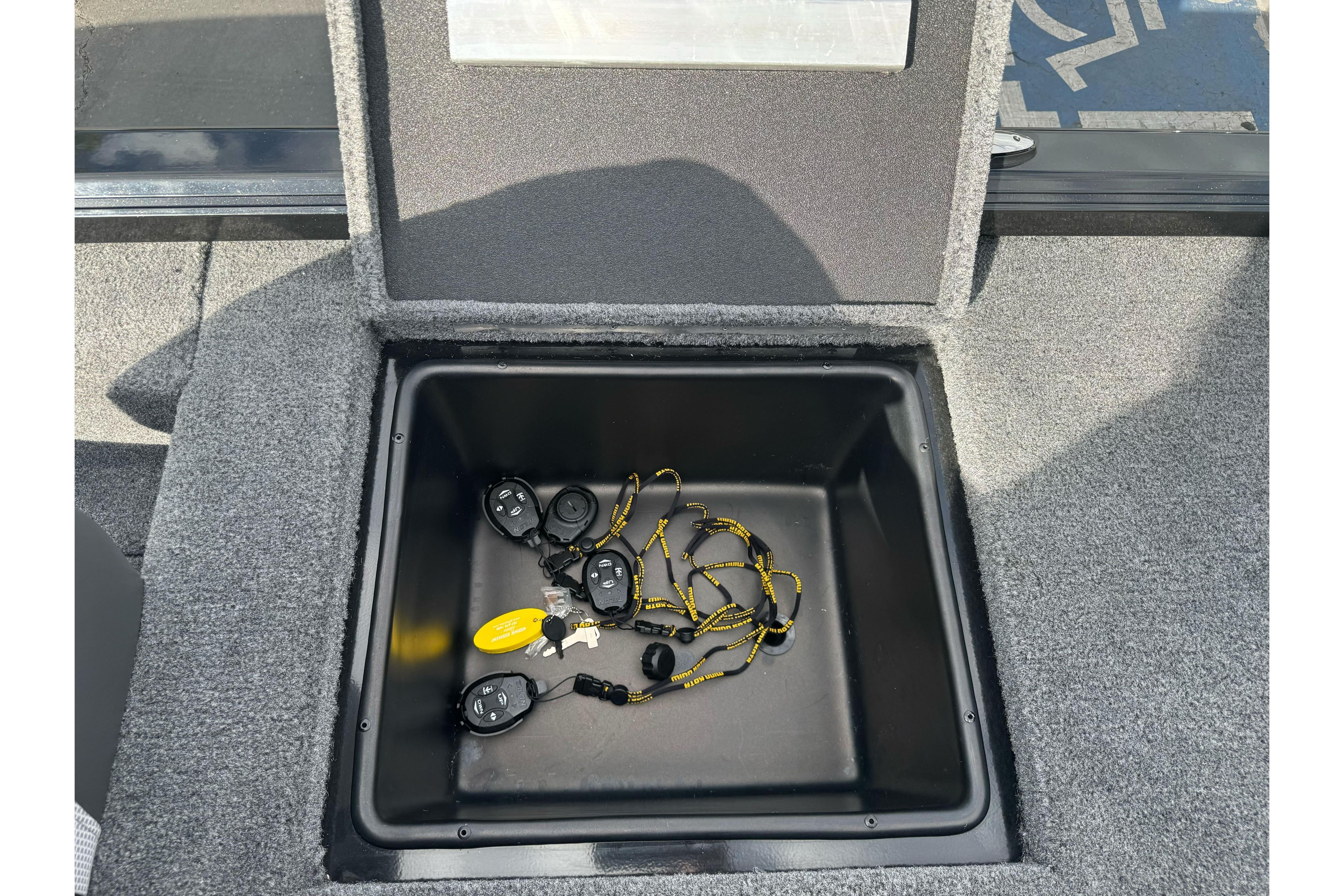 Open storage compartment in 2026 Ranger ALPHA 208 boat with key fobs inside.