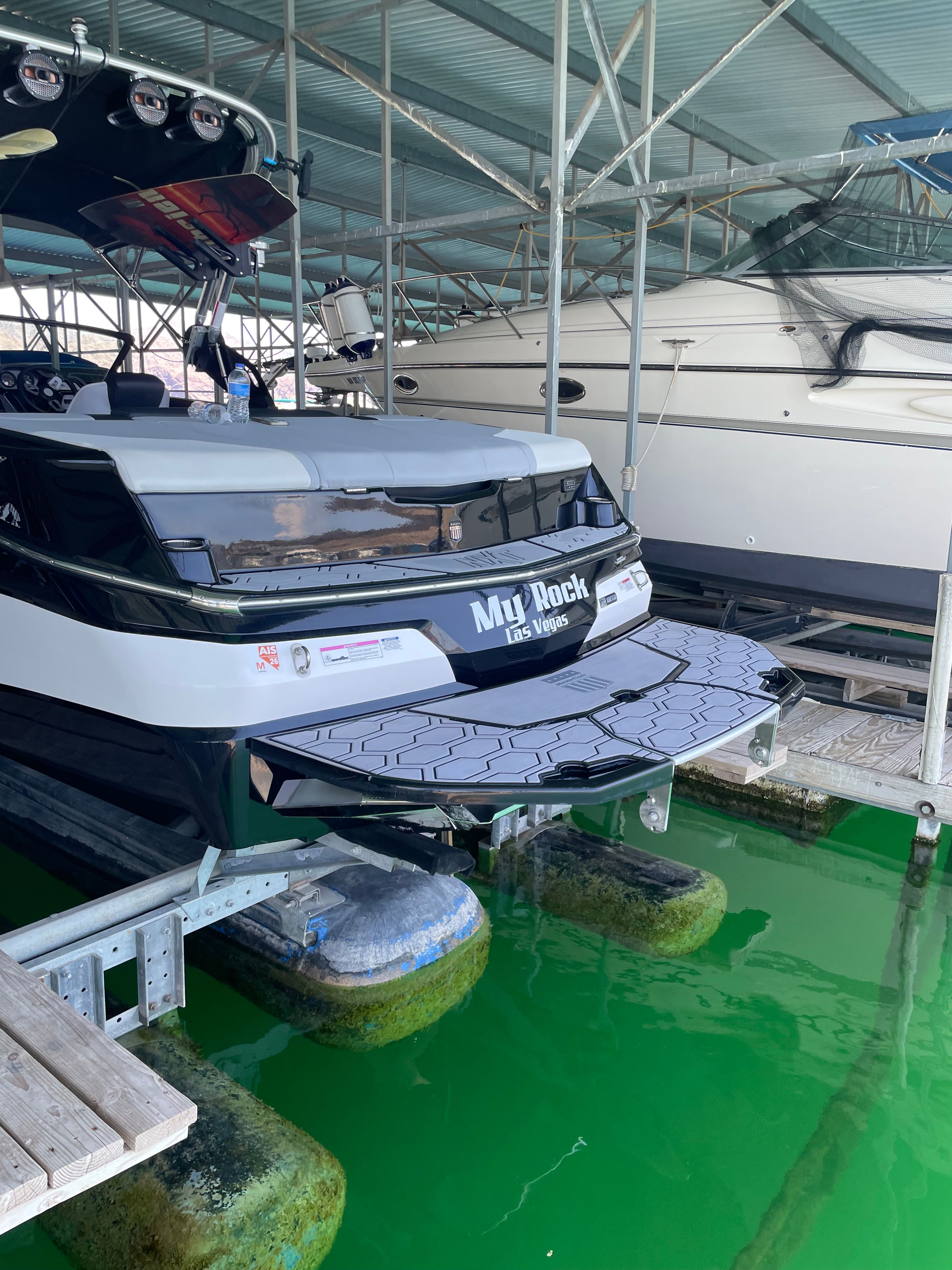 A MasterCraft NXT23 boat is docked in a covered marina.