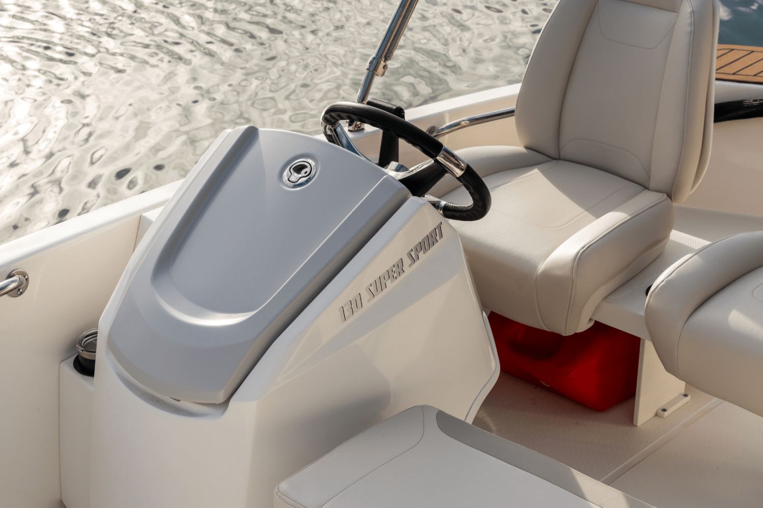 The image shows the cockpit of a 2026 Boston Whaler 130 Super Sport with beige seats.