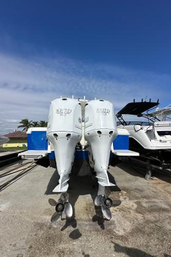 2005 Intrepid 323 boat engines, docked under clear blue sky.