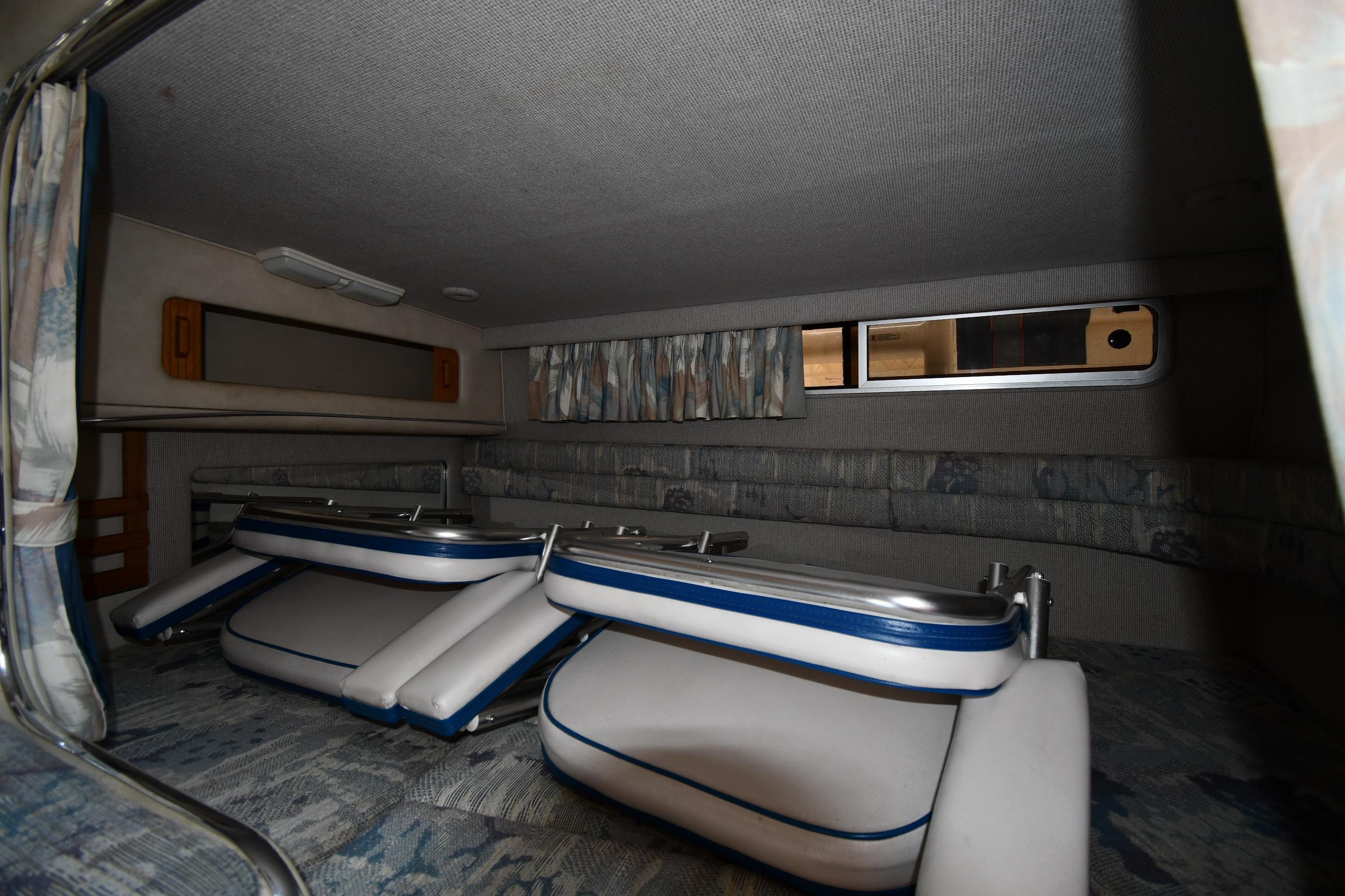 Interior cabin of 1993 Sea Ray 300 Sundancer with folded seating and window.