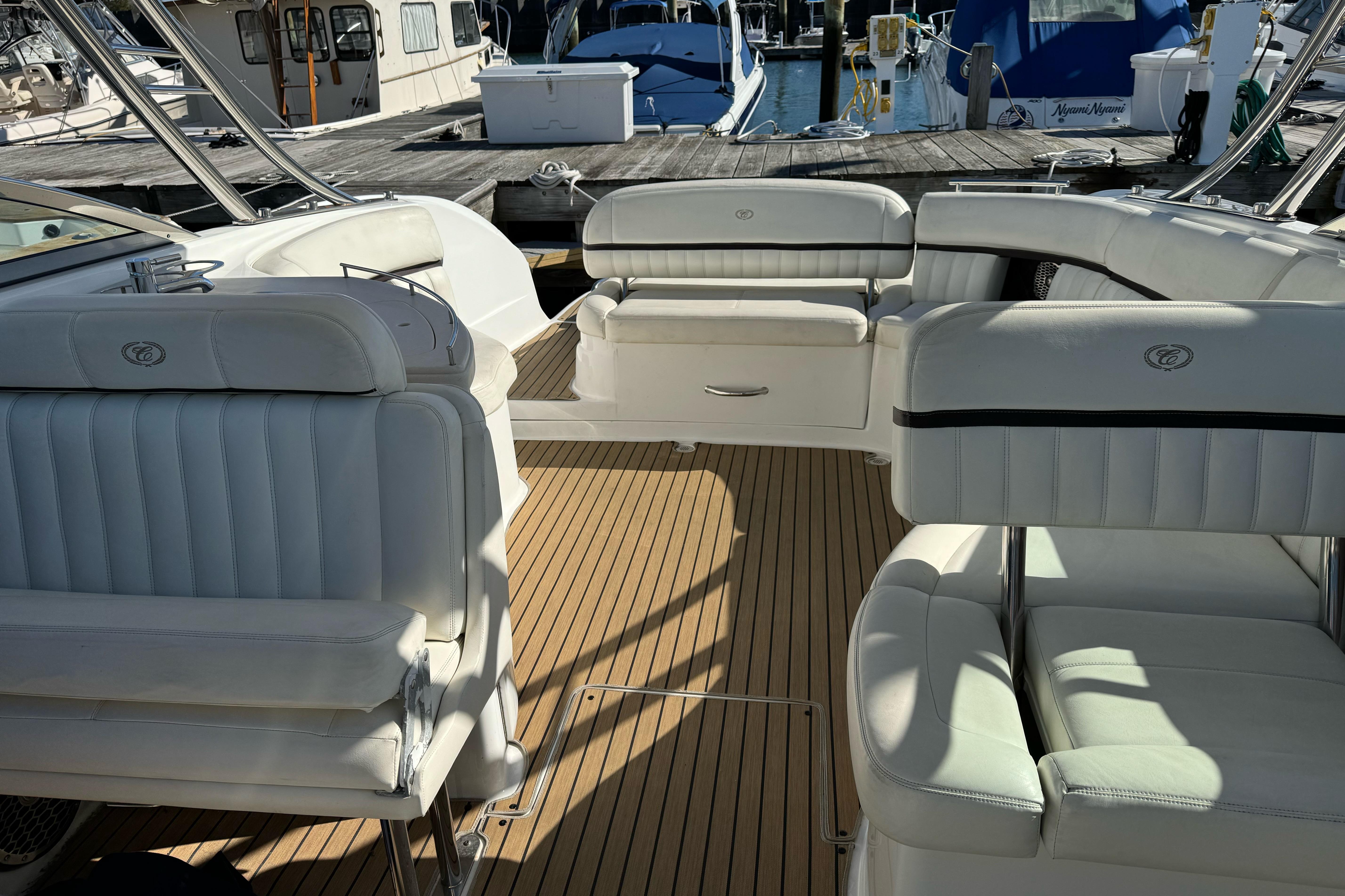 Luxurious interior of a 2013 Cobalt 336 boat with white seating and wooden flooring.
