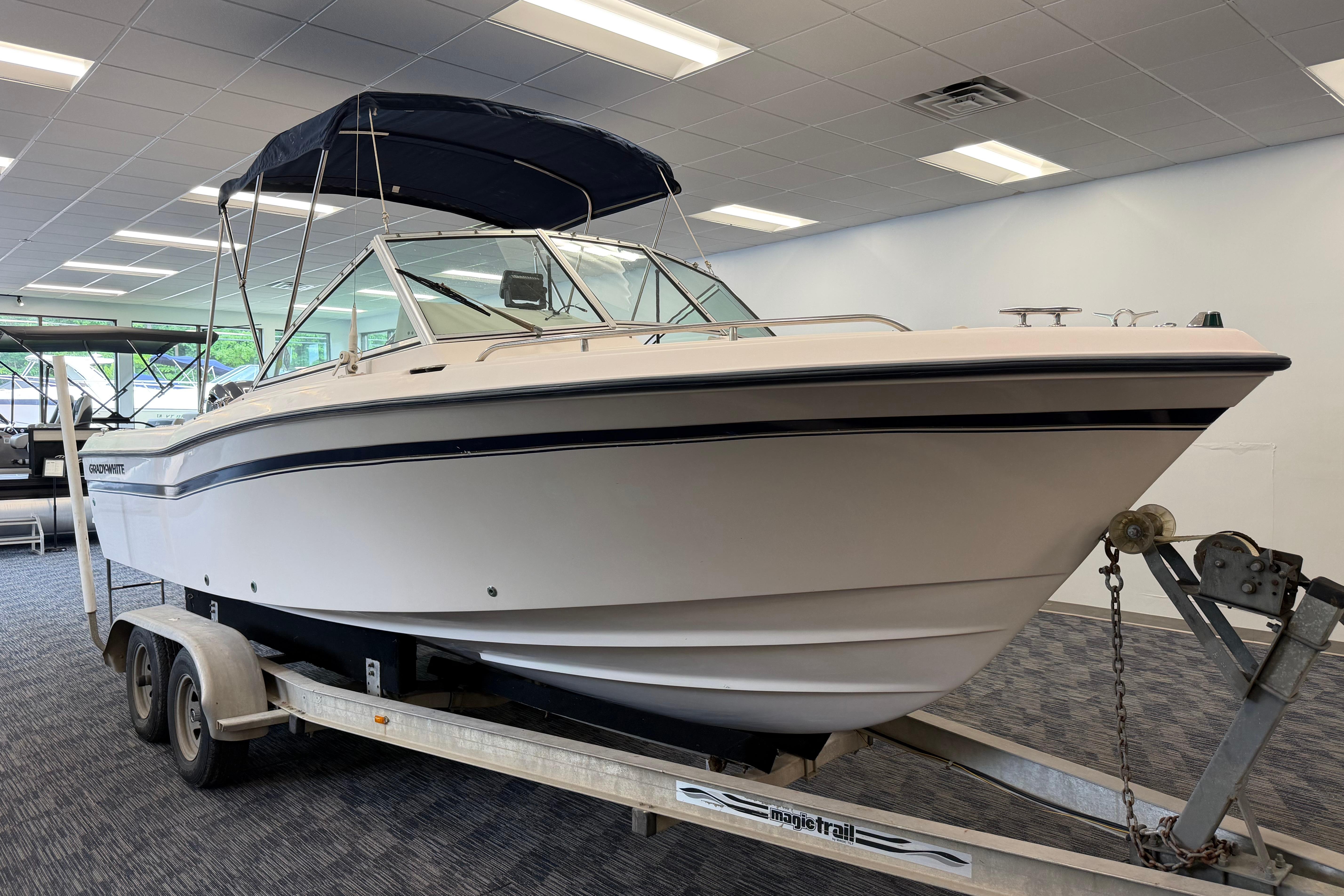 2001 Grady-White Tournament 223 boat on trailer in showroom, featuring a sleek design.