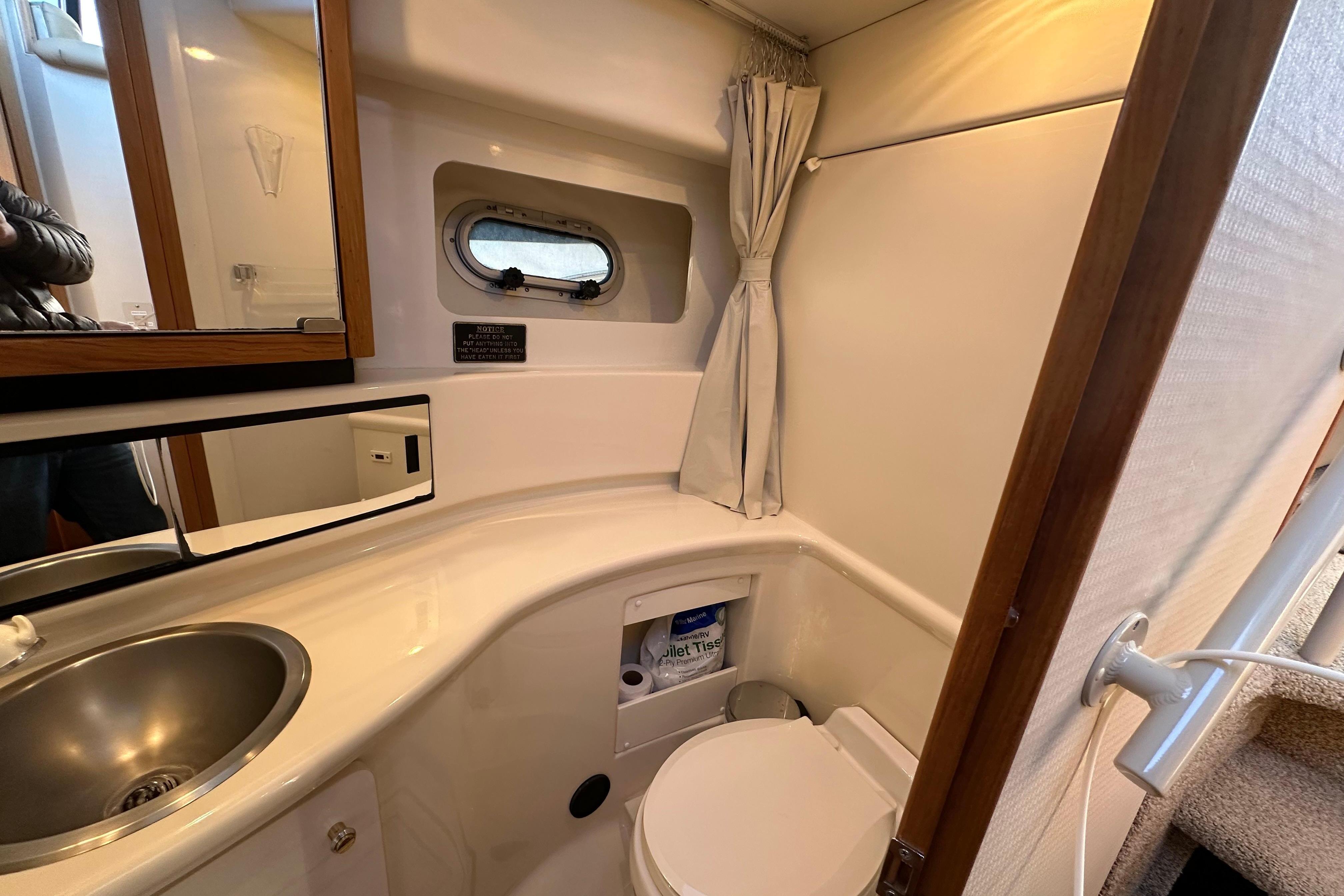 Bathroom interior of 2000 Bayliner 4087 Aft Cabin Motoryacht with sink and toilet.