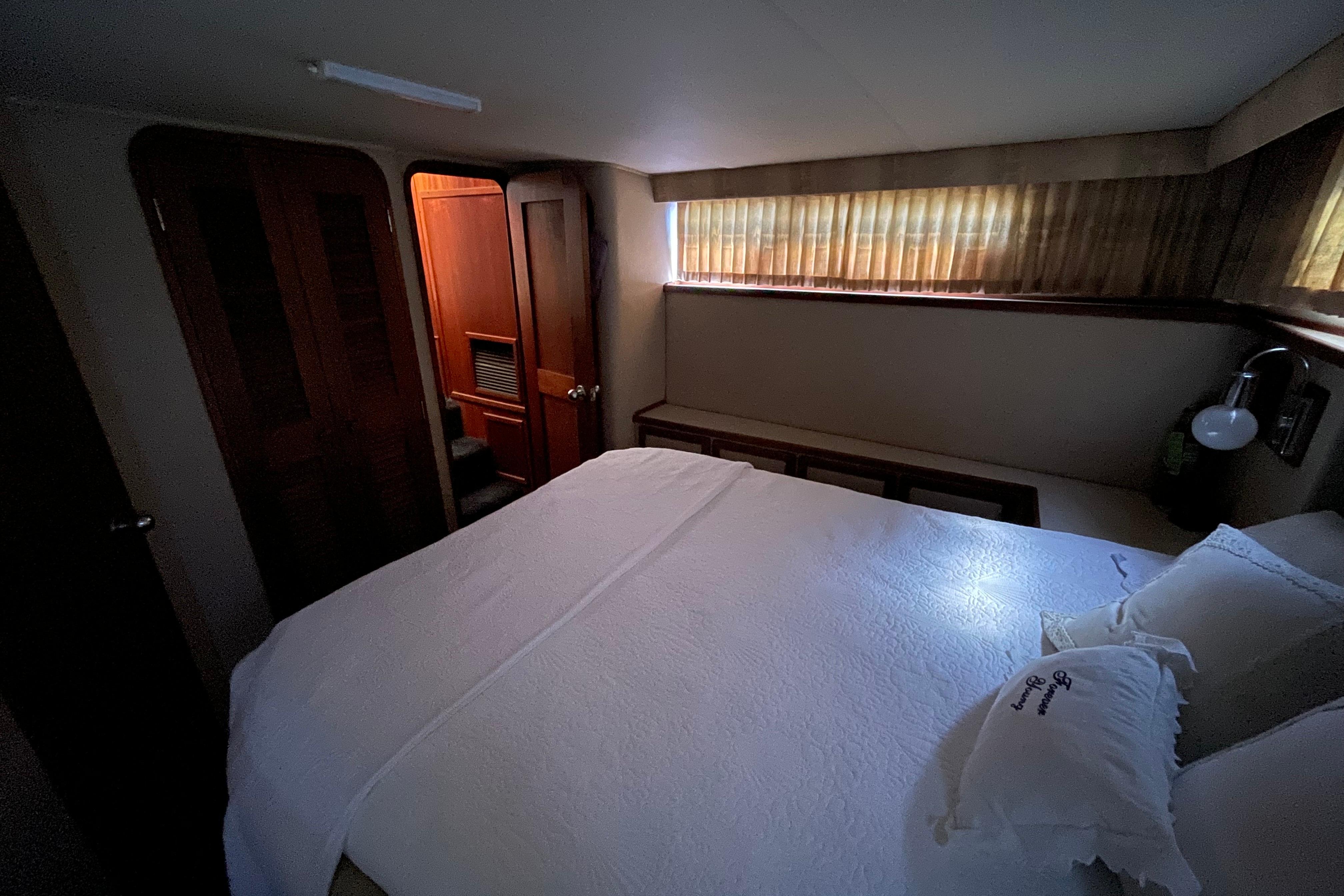 Cozy bedroom interior of 1985 Chris-Craft 426 Catalina yacht with bed and wooden accents.