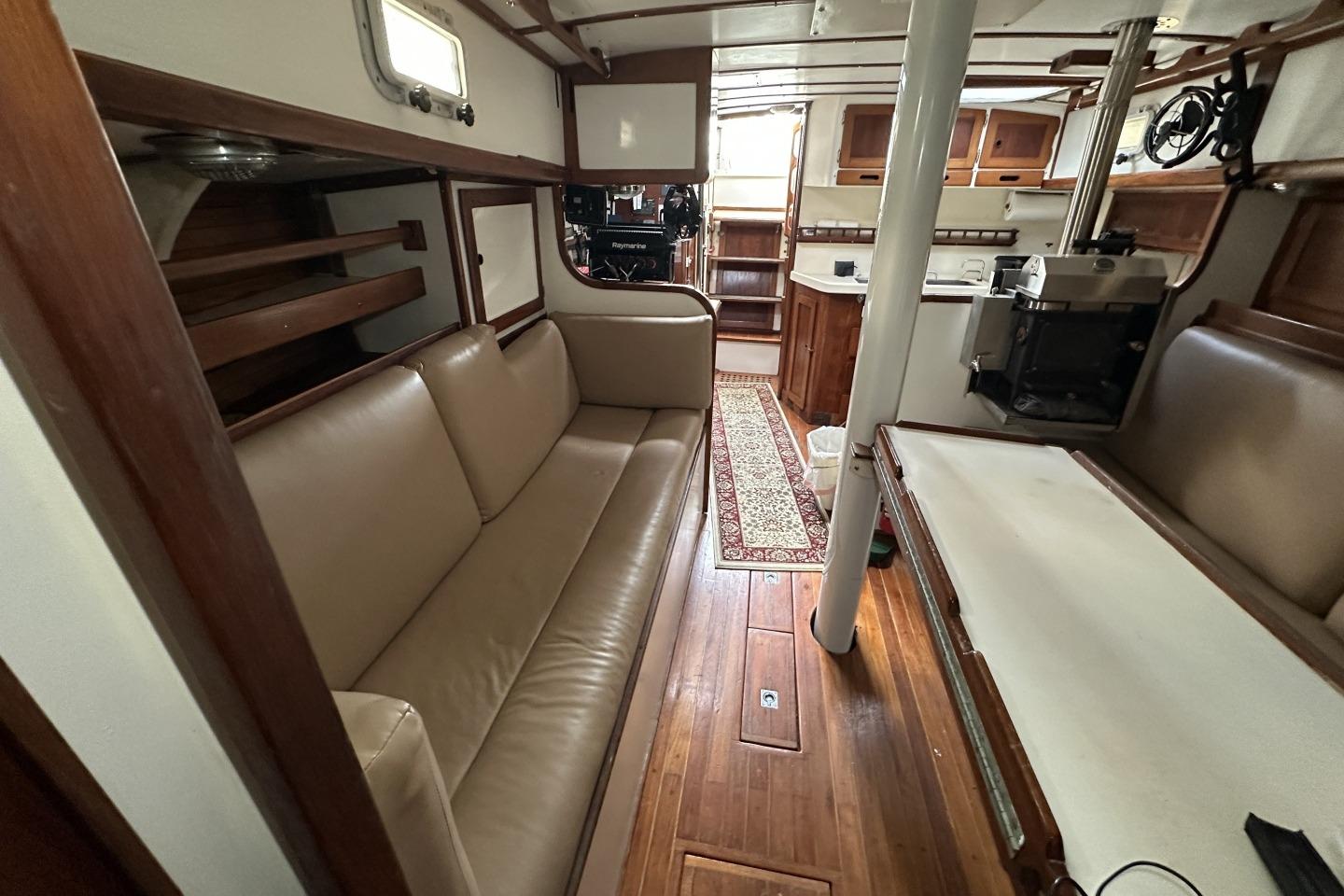 Interior of a 1976 Valiant 40 sailboat with wood accents and cozy seating.