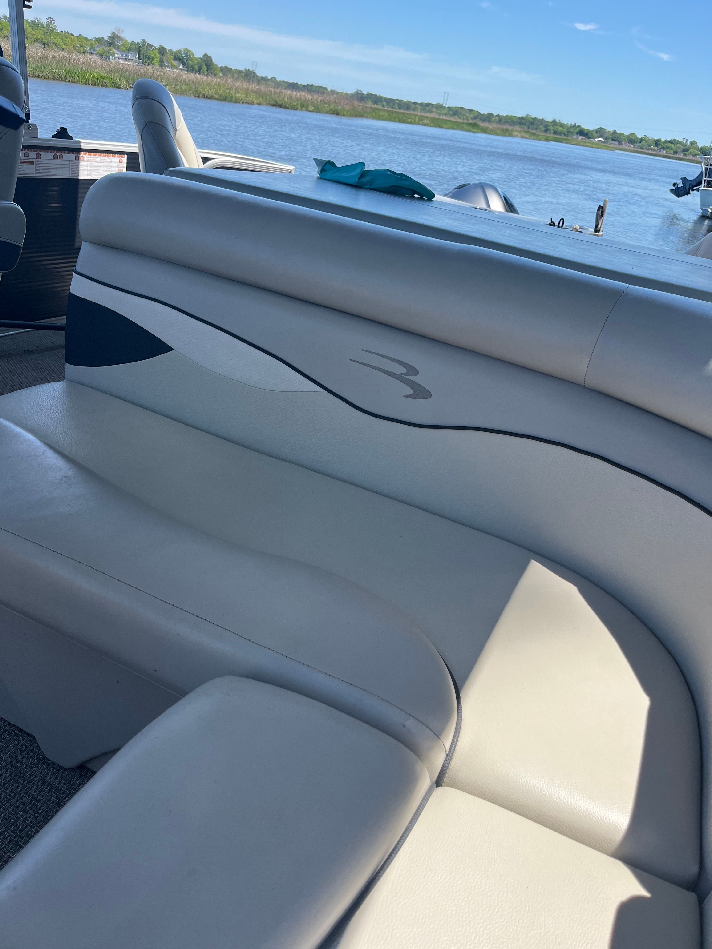 The image shows the interior of a Bennington 23 SX boat with beige seating.