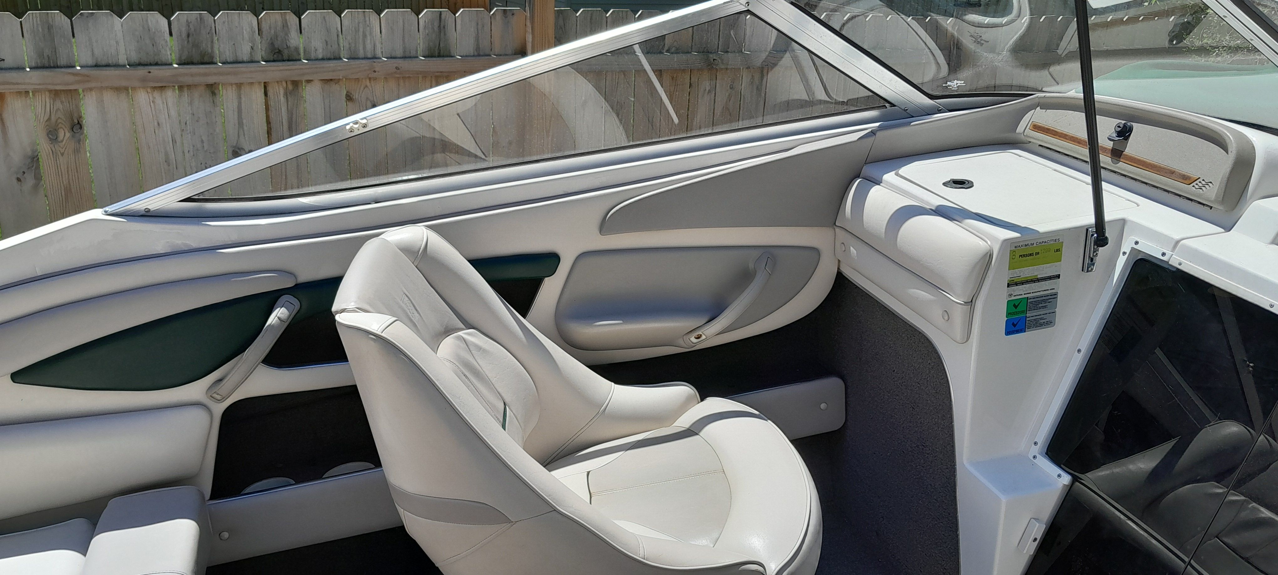 Interior of a 1995 Four Winns 205 Sundowner boat, featuring white leather seats.