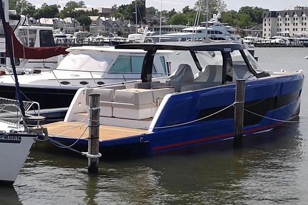 2023 Fjord 41 XL luxury yacht docked in marina, featuring sleek blue design and spacious deck.