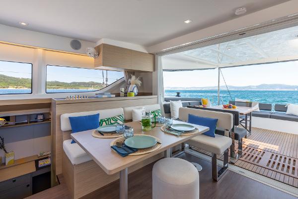 Luxurious interior of 2025 Lagoon 43 yacht with ocean view and elegant dining setup.