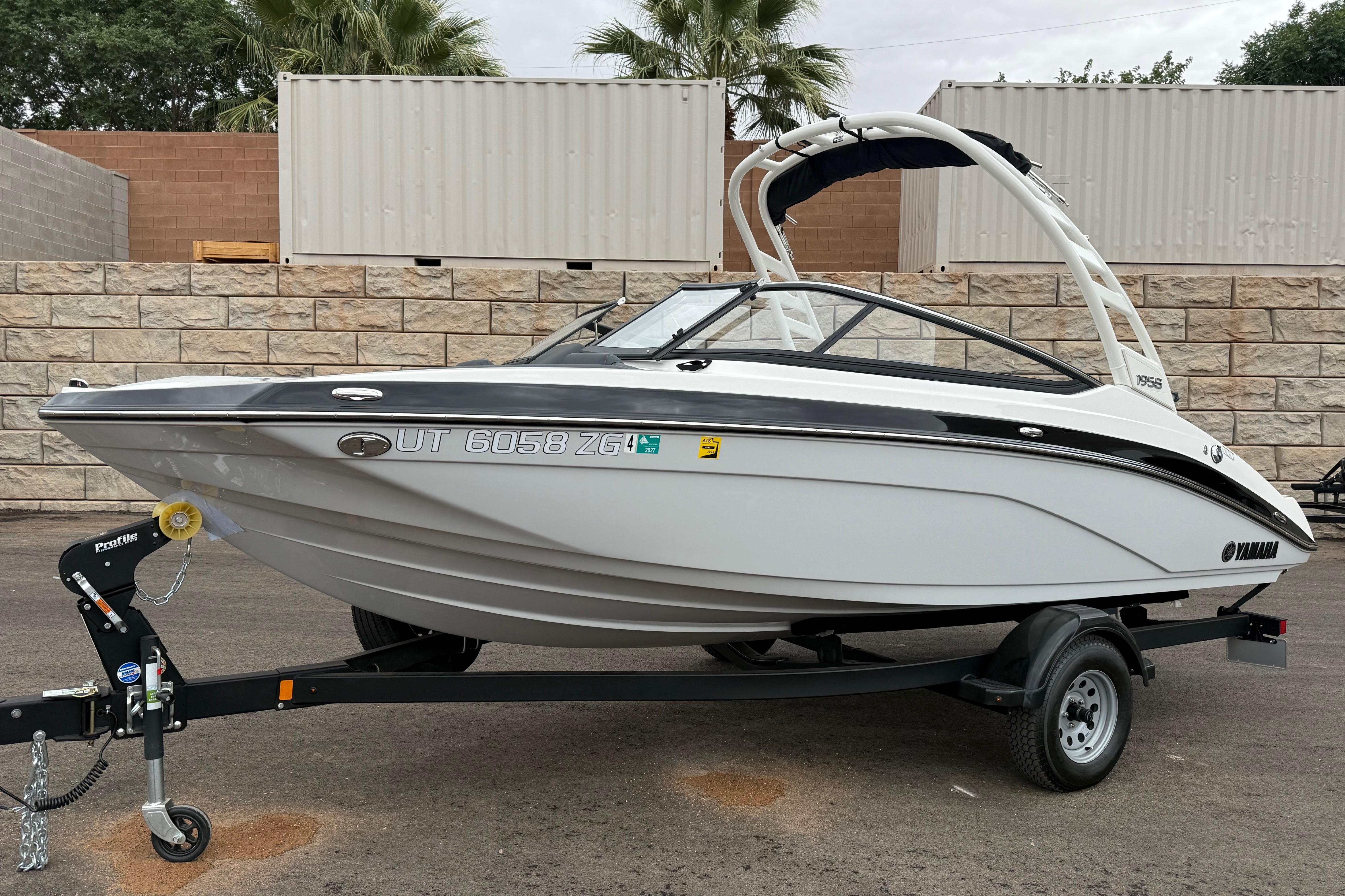 2025 Yamaha Boats 195S on trailer, parked outdoors with stone wall background.