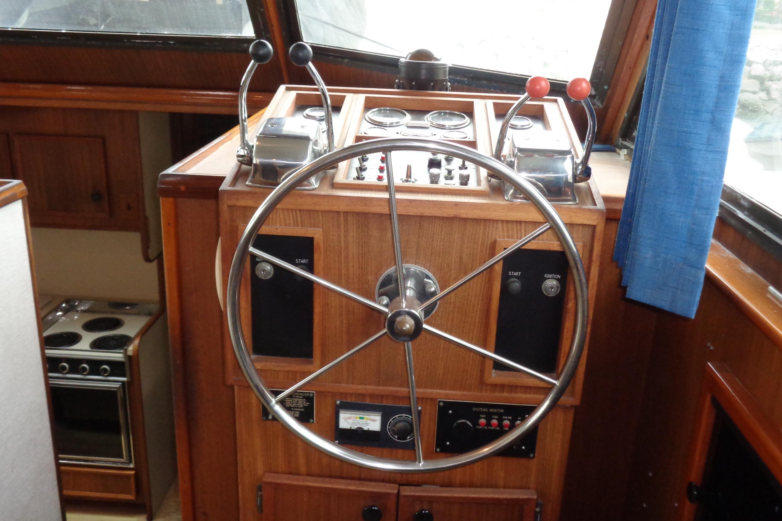 Helm of 1981 Hatteras 48 Cockpit Motor Yacht with steering wheel and controls.