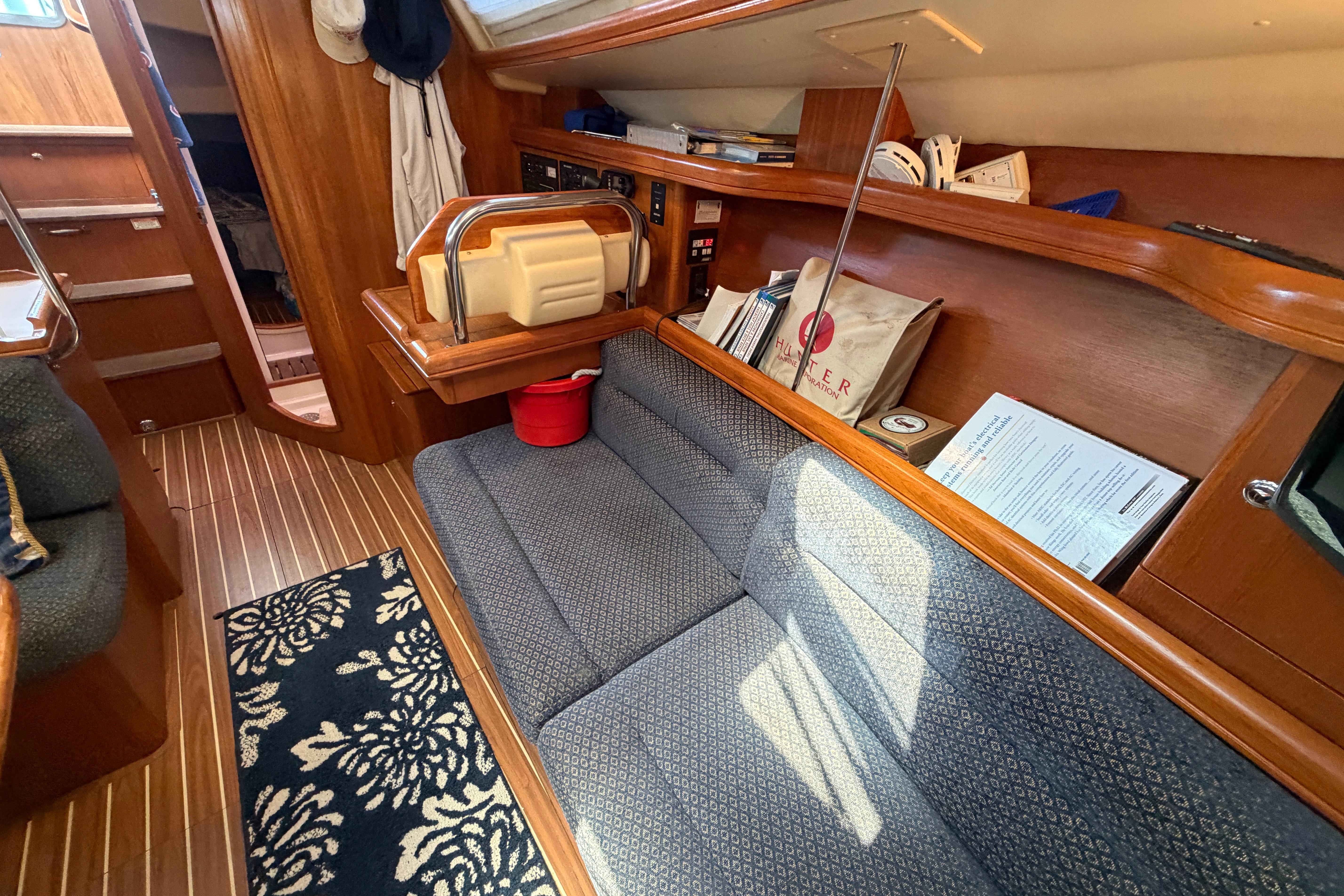 Interior of a 2005 Hunter 38 sailboat with wooden finishes and cozy seating.