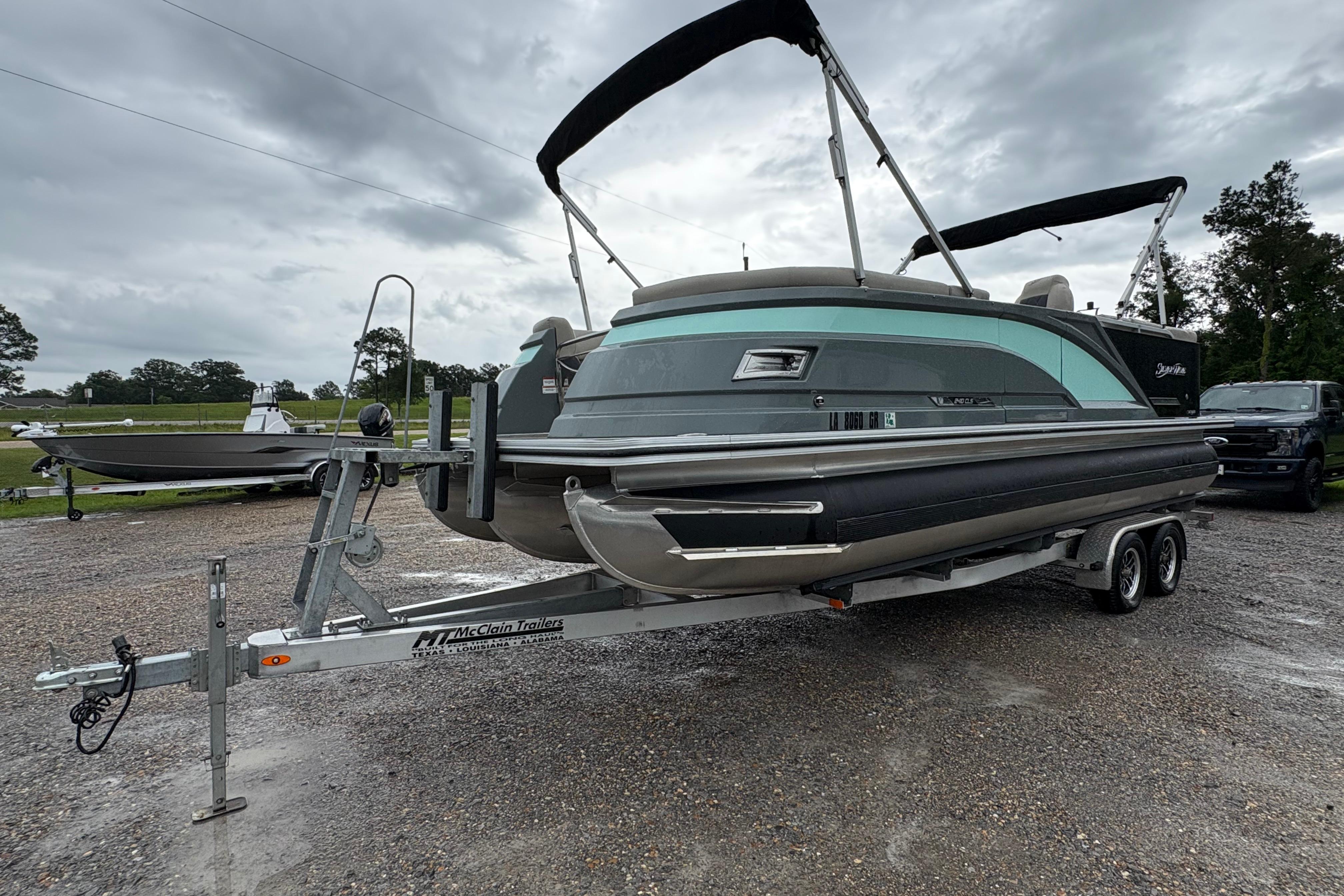 2023 SilverWave 2410 CLS pontoon boat on trailer, overcast sky background.