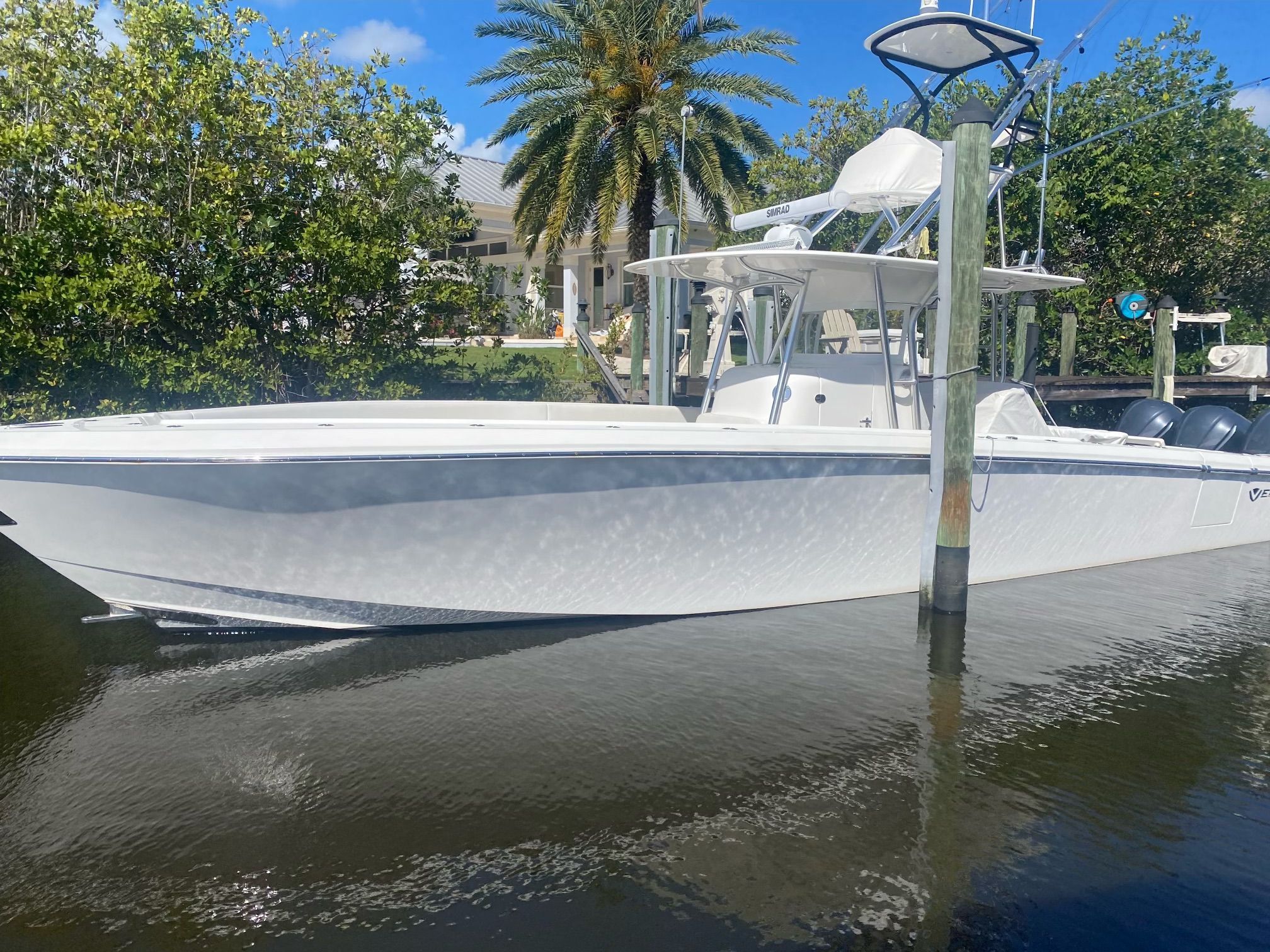 2019 Venture CC boat in water, surrounded by palm trees.