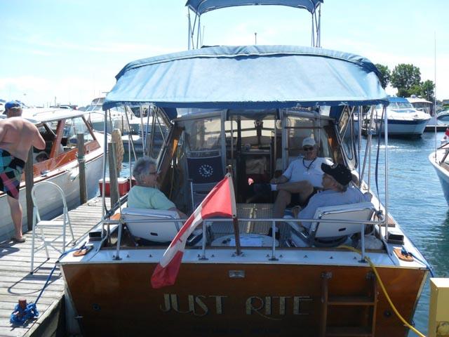 1967 Chris-Craft Sea Skiff 32 Sport Cruiser docked with people relaxing onboard.