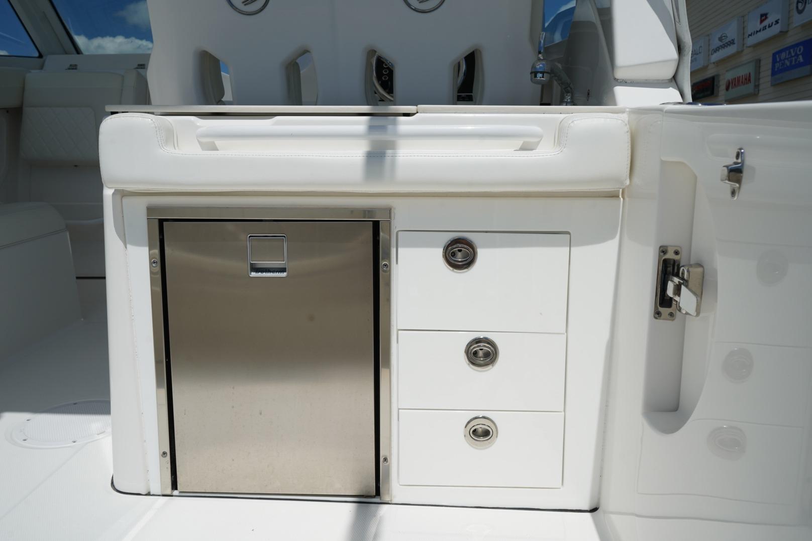 2020 Edgewater 262CX Crossover boat interior with stainless steel storage and white seating.