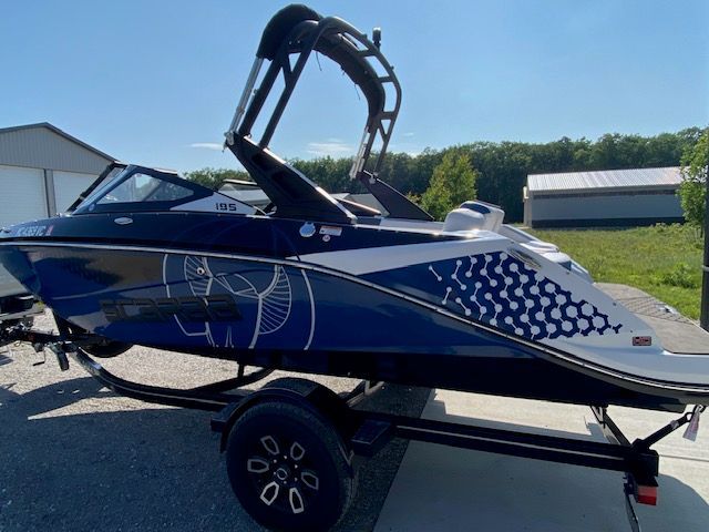 2024 Scarab 195 ID with distinctive design and tower, parked on a trailer outdoors.