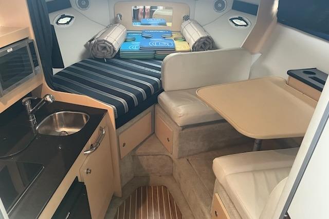 Interior of 2012 Bayliner 285 Cruiser with kitchenette, seating, and sleeping area.
