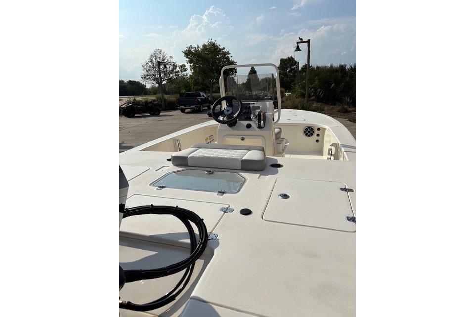 2026 Mako 18 Pro Skiff boat with console and seating, parked outdoors.