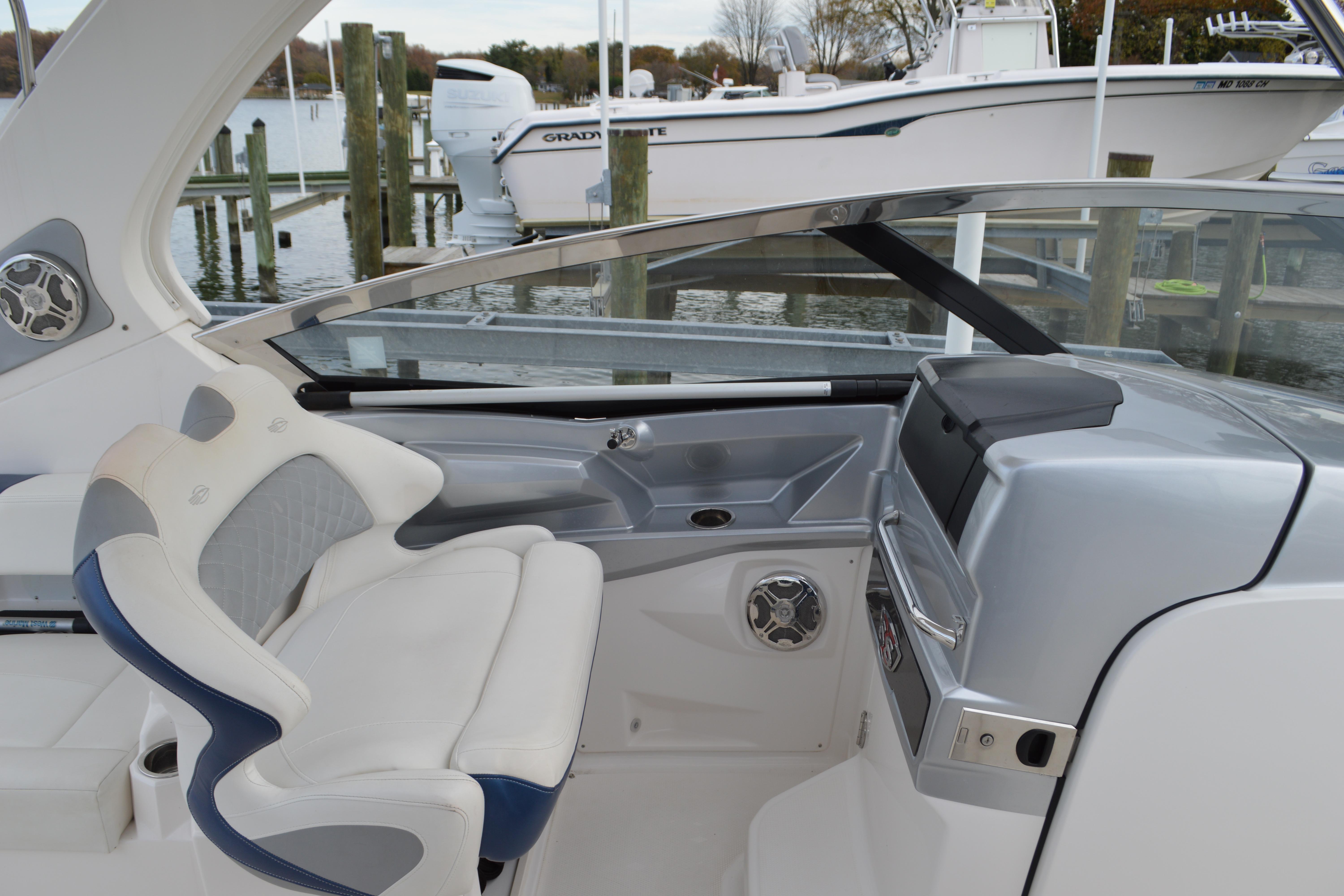 2013 Chaparral 327 SSX boat cockpit with helm and seating at marina.