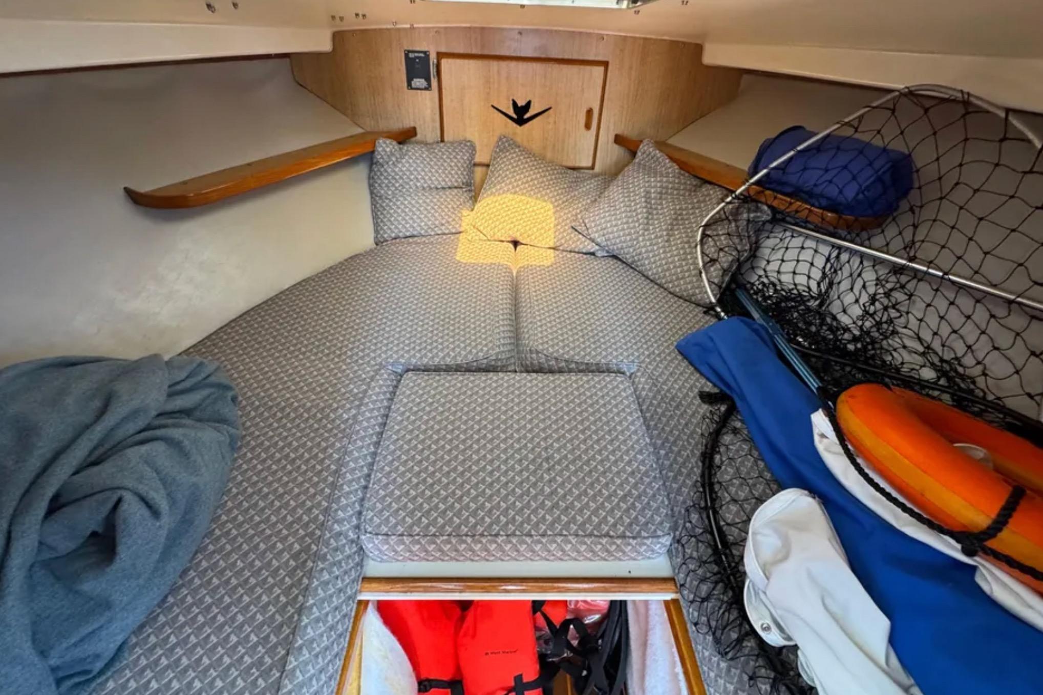 1988 Bertram 28 Sport Fisherman cabin interior with cushions, fishing net, and life preserver.