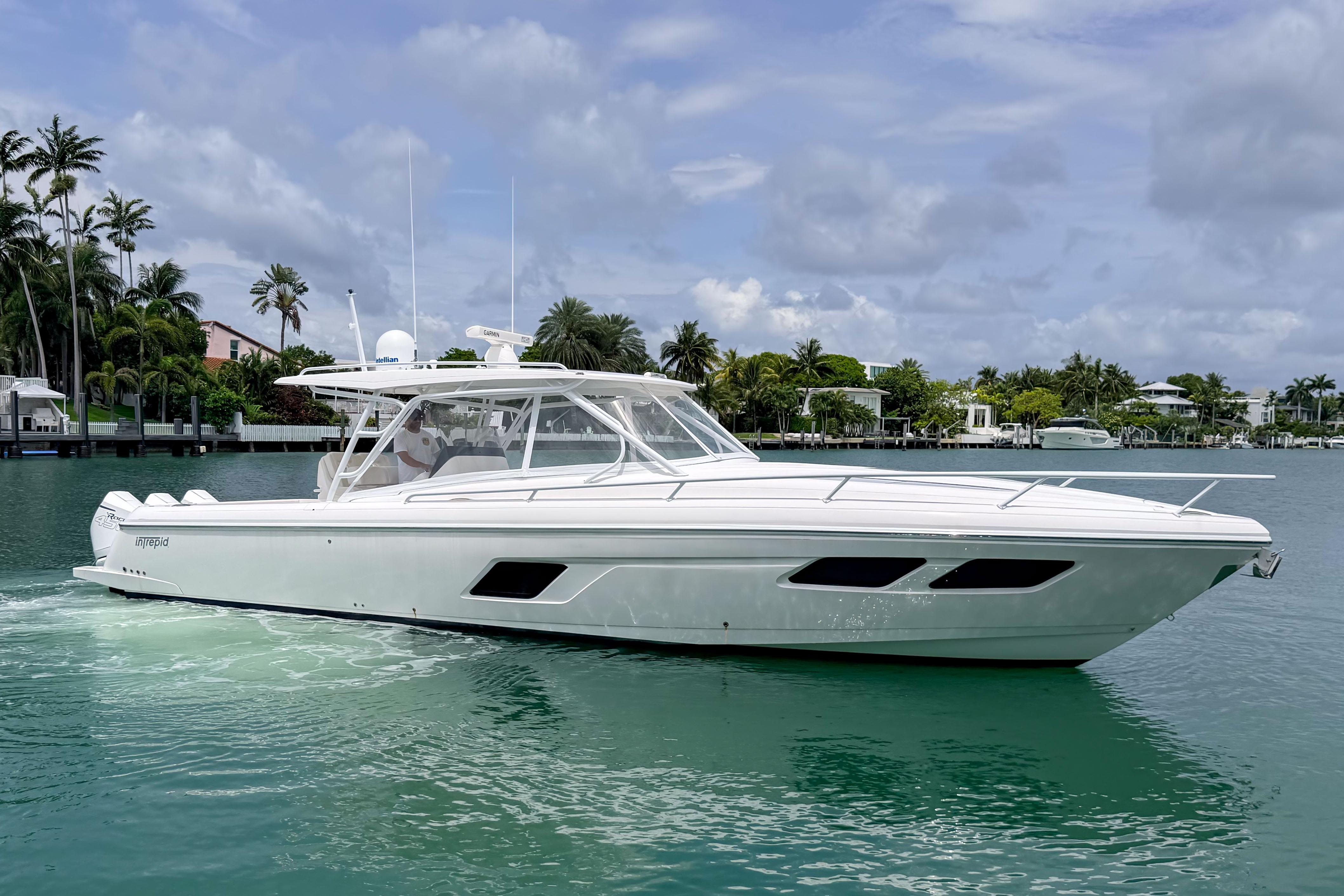 2021 Intrepid 409 Valor yacht cruising on a serene tropical waterway.