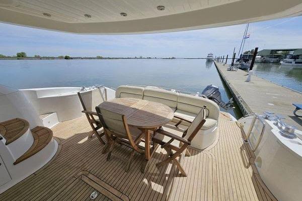 Luxurious 2005 Sunseeker Manhattan 66 yacht deck with seating and scenic waterfront view.
