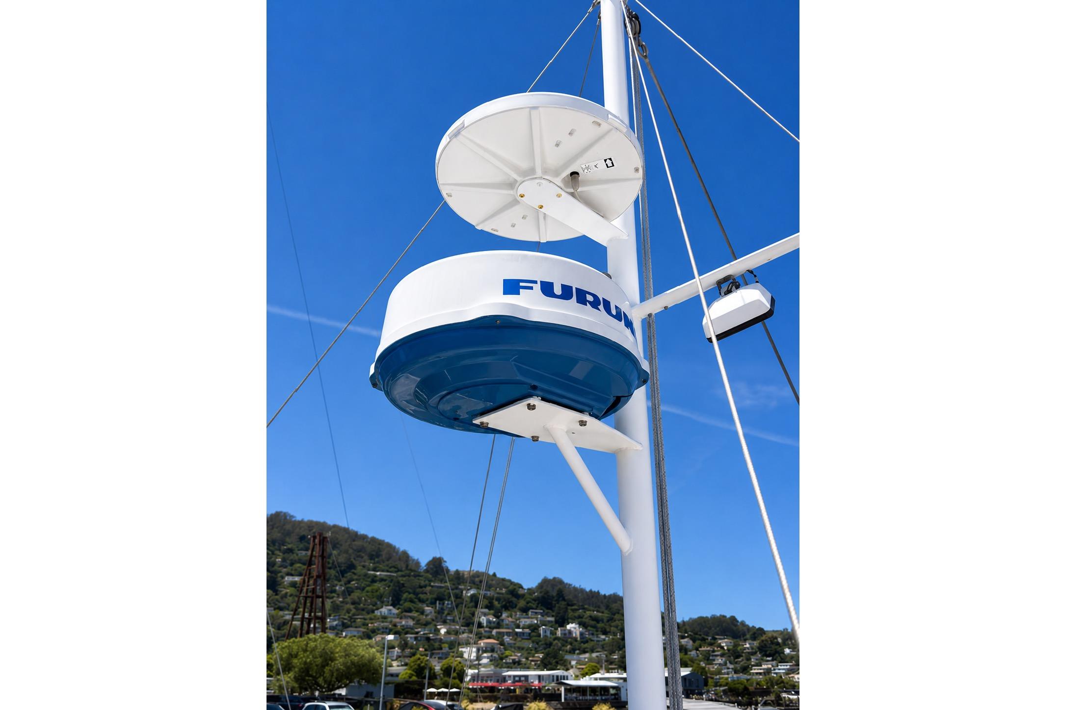 Radar equipment on a 1989 Grand Banks 42 Classic boat against a clear blue sky.
