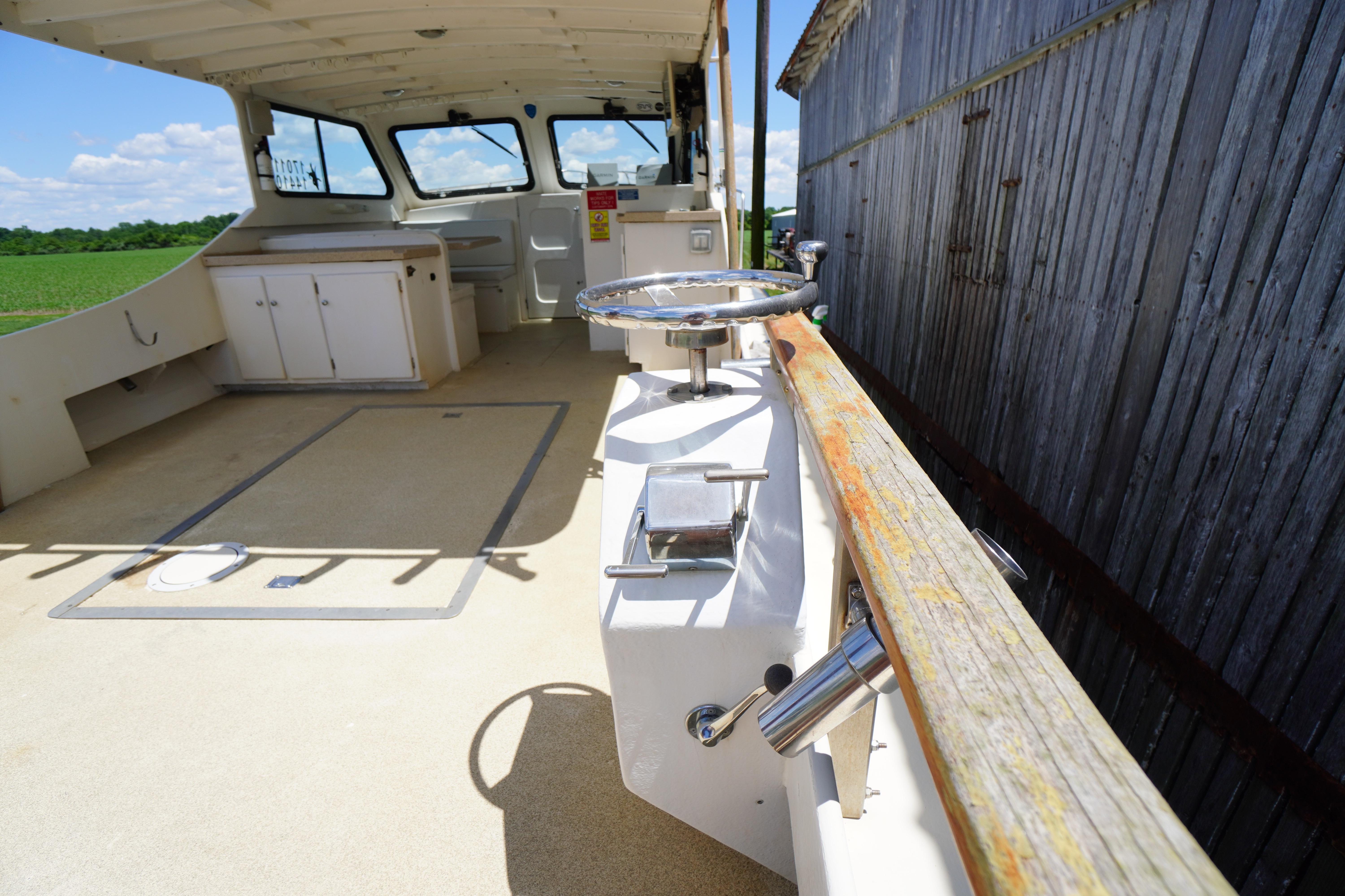 1989 Markley 35 Ft. Deadrise boat interior with steering wheel and cabinets.
