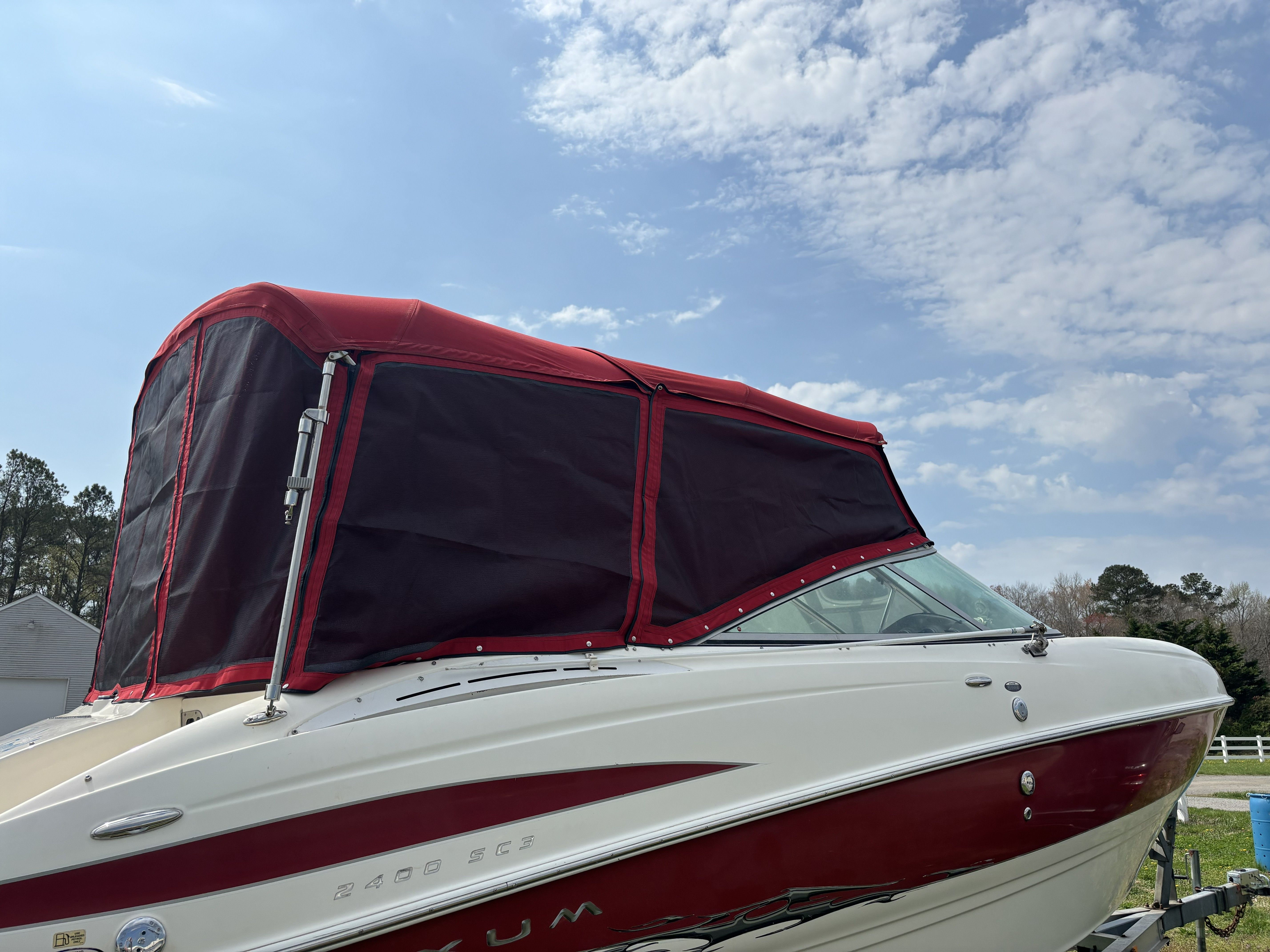 2005 Maxum 2400 SC3 boat with red canopy under blue sky.