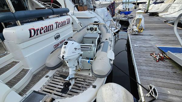 2005 Neptunus 56 Flybridge yacht with inflatable boat at marina dock.