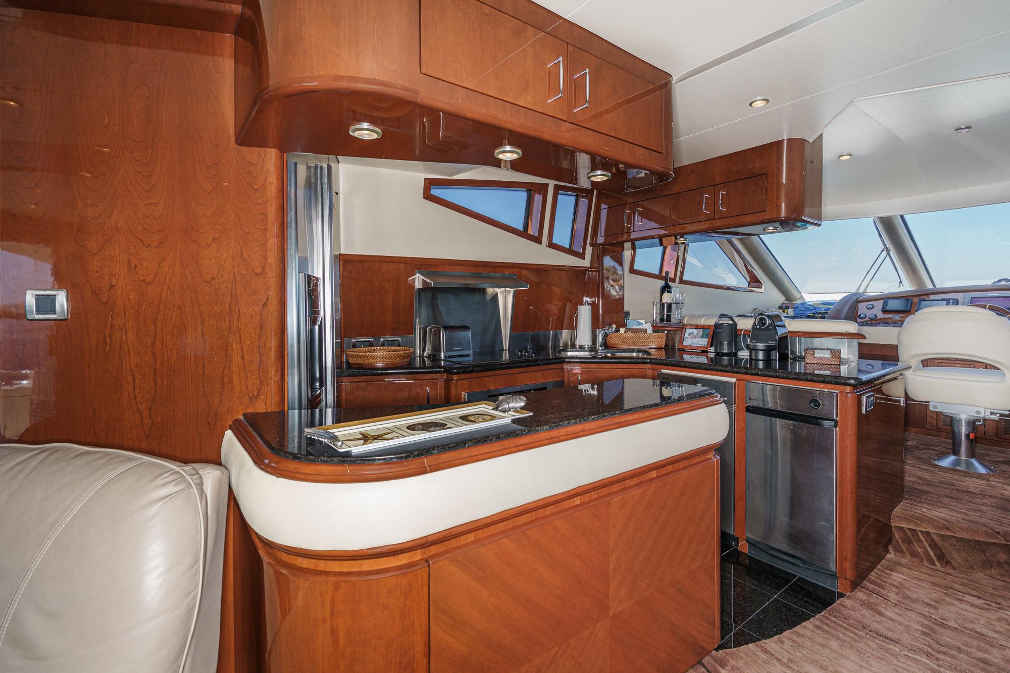 Luxurious 2005 Marquis 65 yacht interior with modern kitchen and elegant wood finishes.