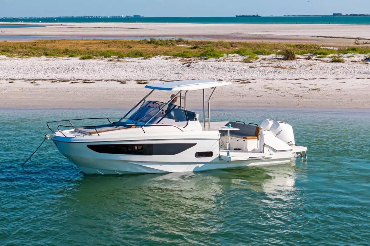 2026 Beneteau Flyer 9 SUNdeck near a sandy shore.
