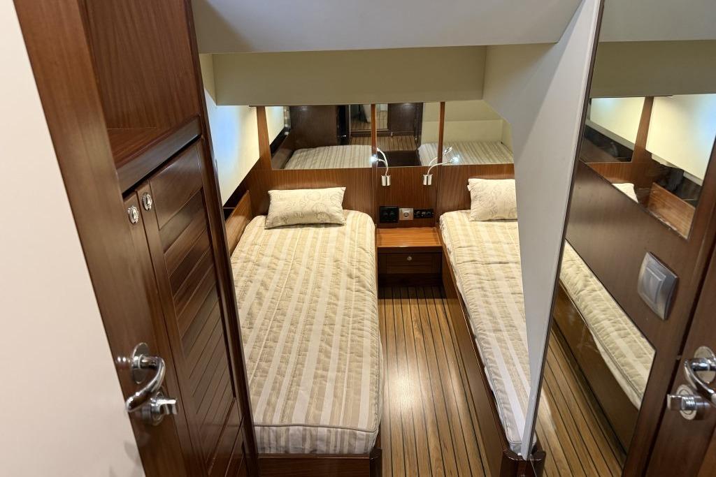 Cozy twin cabin interior of 2012 Sasga Yachts Menorquin 42 with wooden finishes.