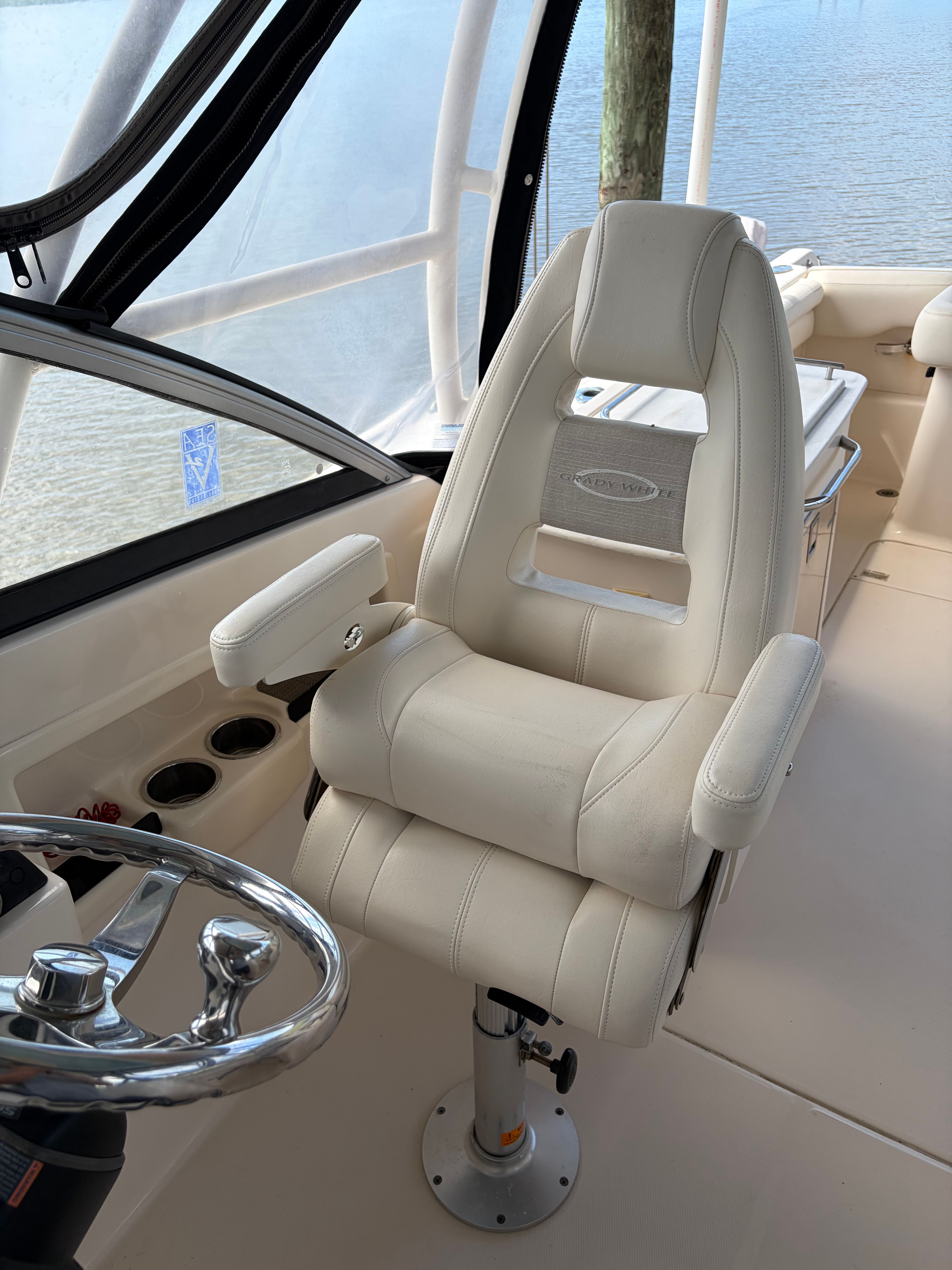 A luxurious captain's chair on a Grady-White Freedom 275 boat, overlooking the water.