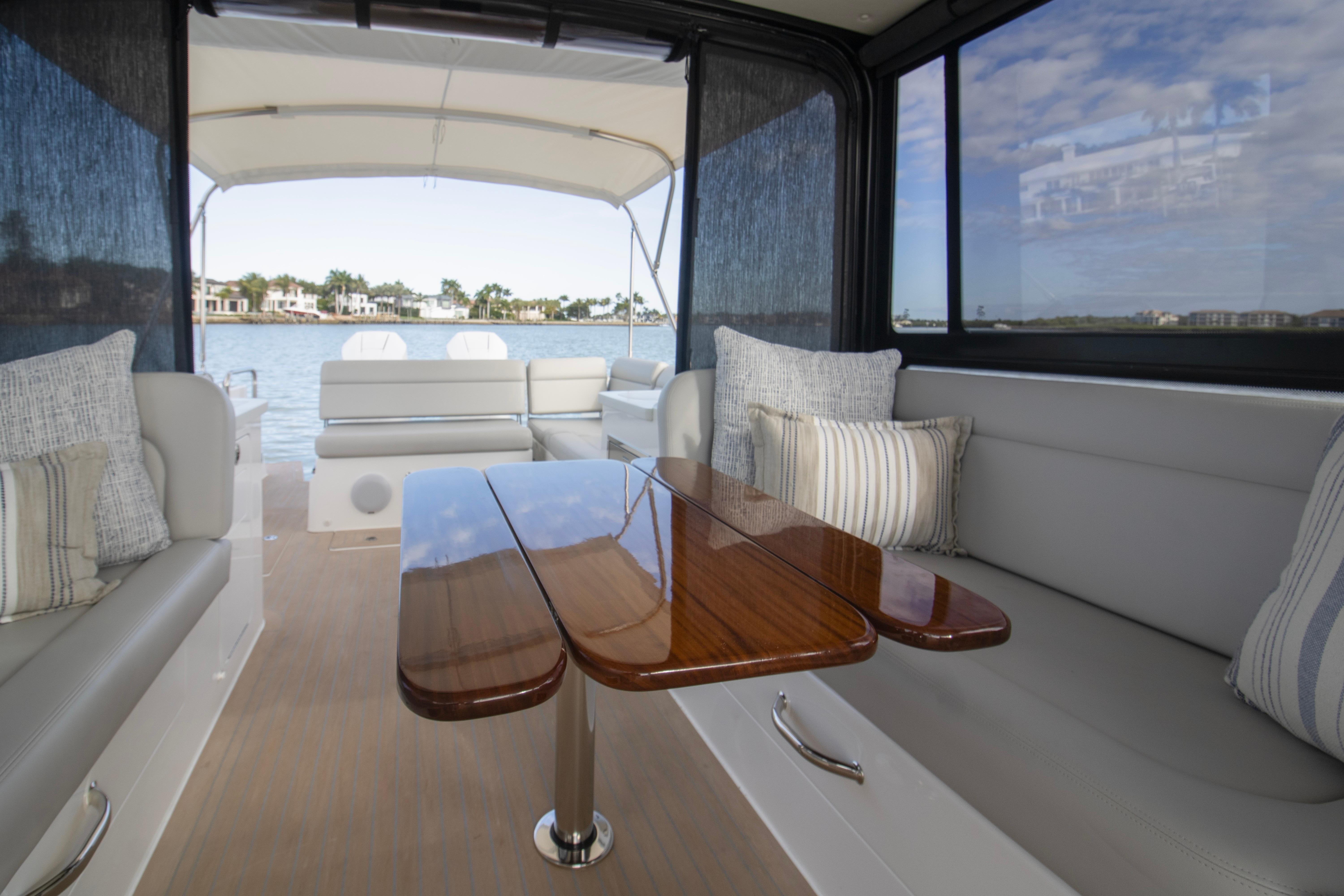 Luxurious interior of 2025 MJM 38 X yacht with elegant seating and wooden table.