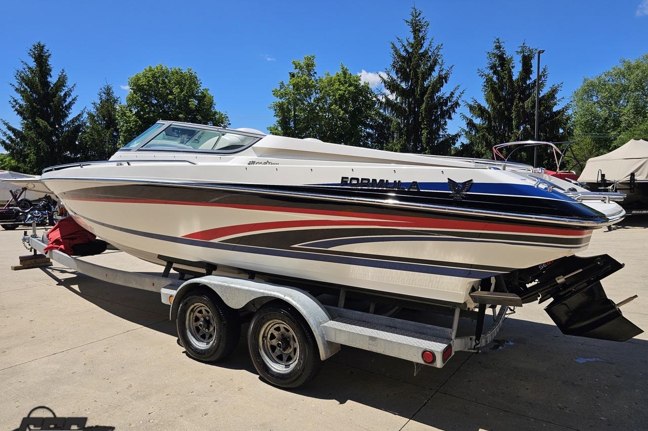 2005 Formula 271 FASTech boat on trailer, parked outdoors with trees in background.