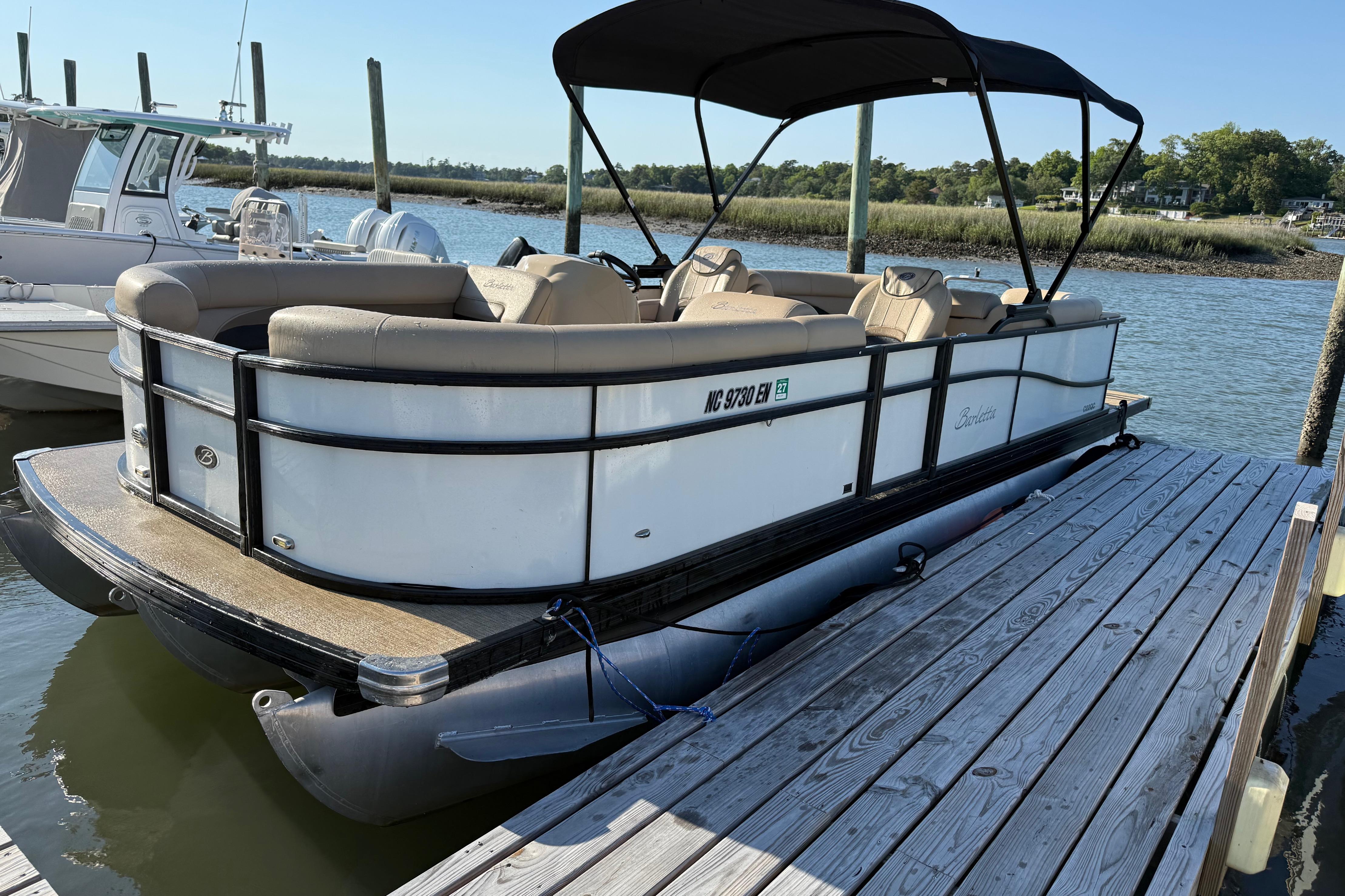 2021 Barletta C22QC pontoon boat docked on a sunny day.