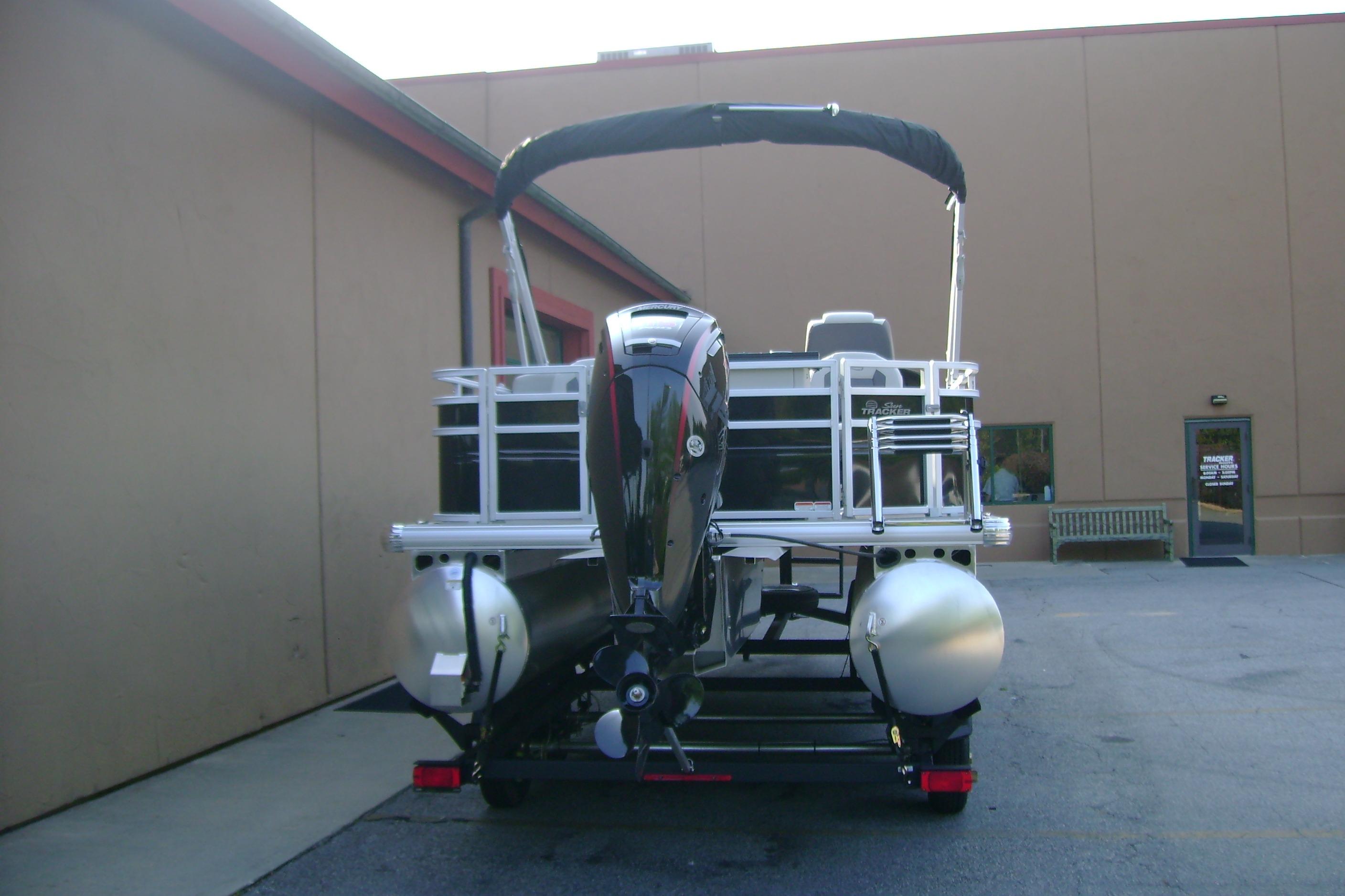 2026 Sun Tracker Fishin' Barge 20 DLX pontoon boat, rear view, parked outdoors.