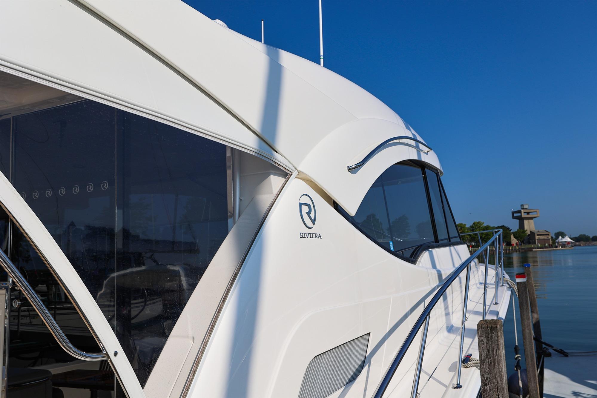 2016 Riviera 525 SUV yacht docked by calm waters, showcasing sleek design and luxury features.