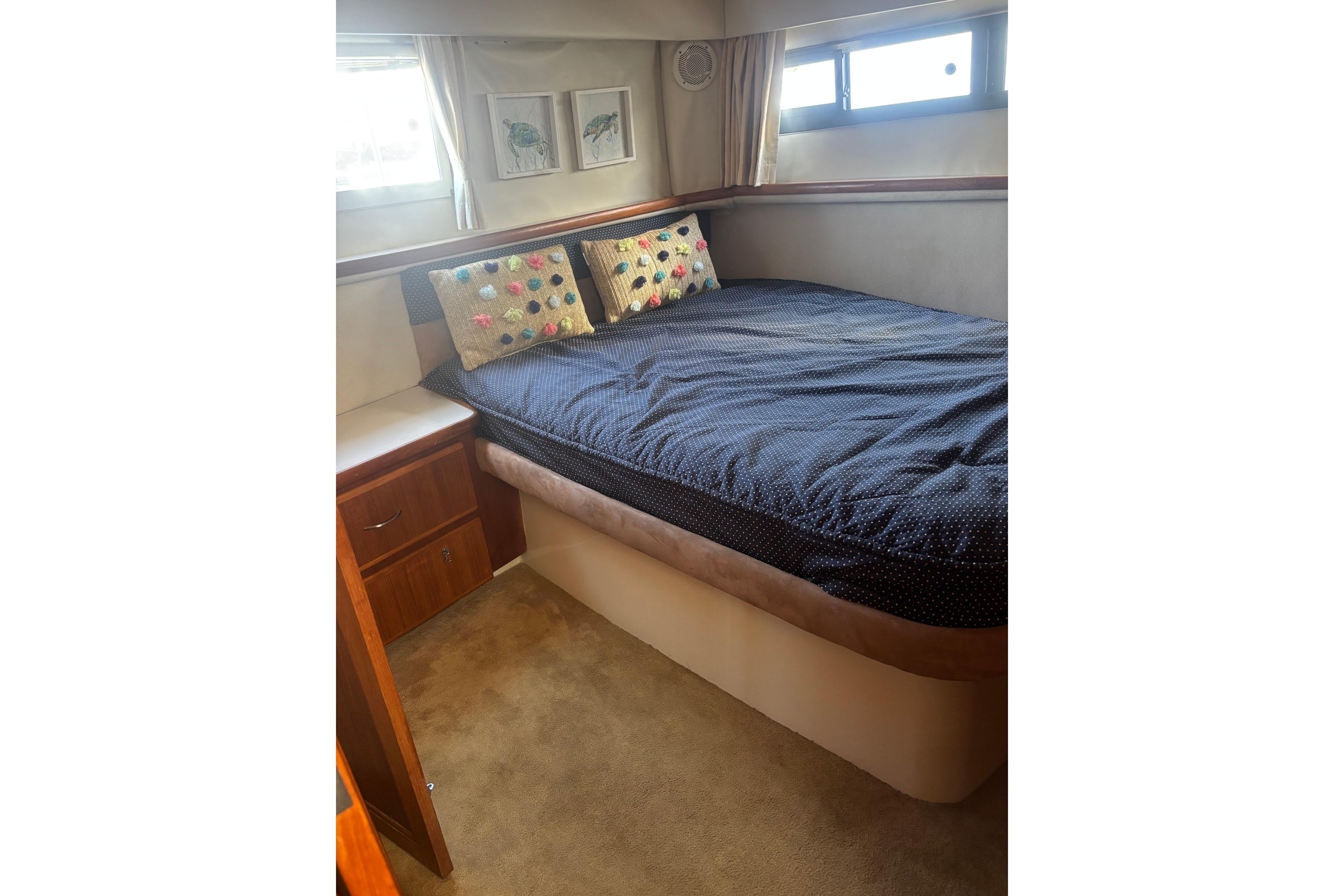 Cozy bedroom in 1995 Carver 356 Aft Cabin Motor Yacht with decorative pillows.
