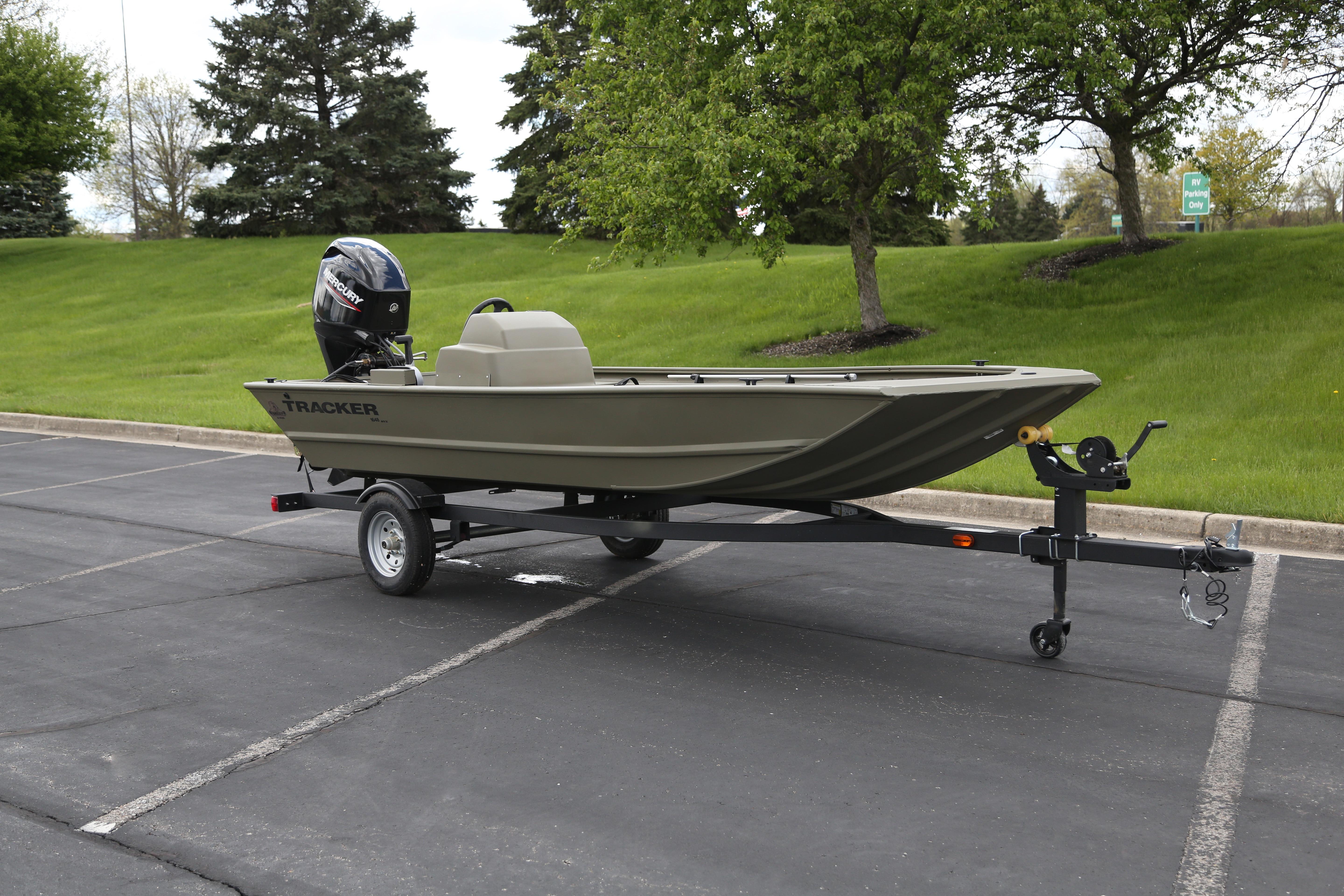 2026 Tracker Grizzly 1648 SC boat on trailer in parking lot.