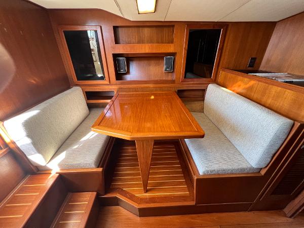 Interior of the 1985 Viking 35 Express with wooden table and cushioned benches.