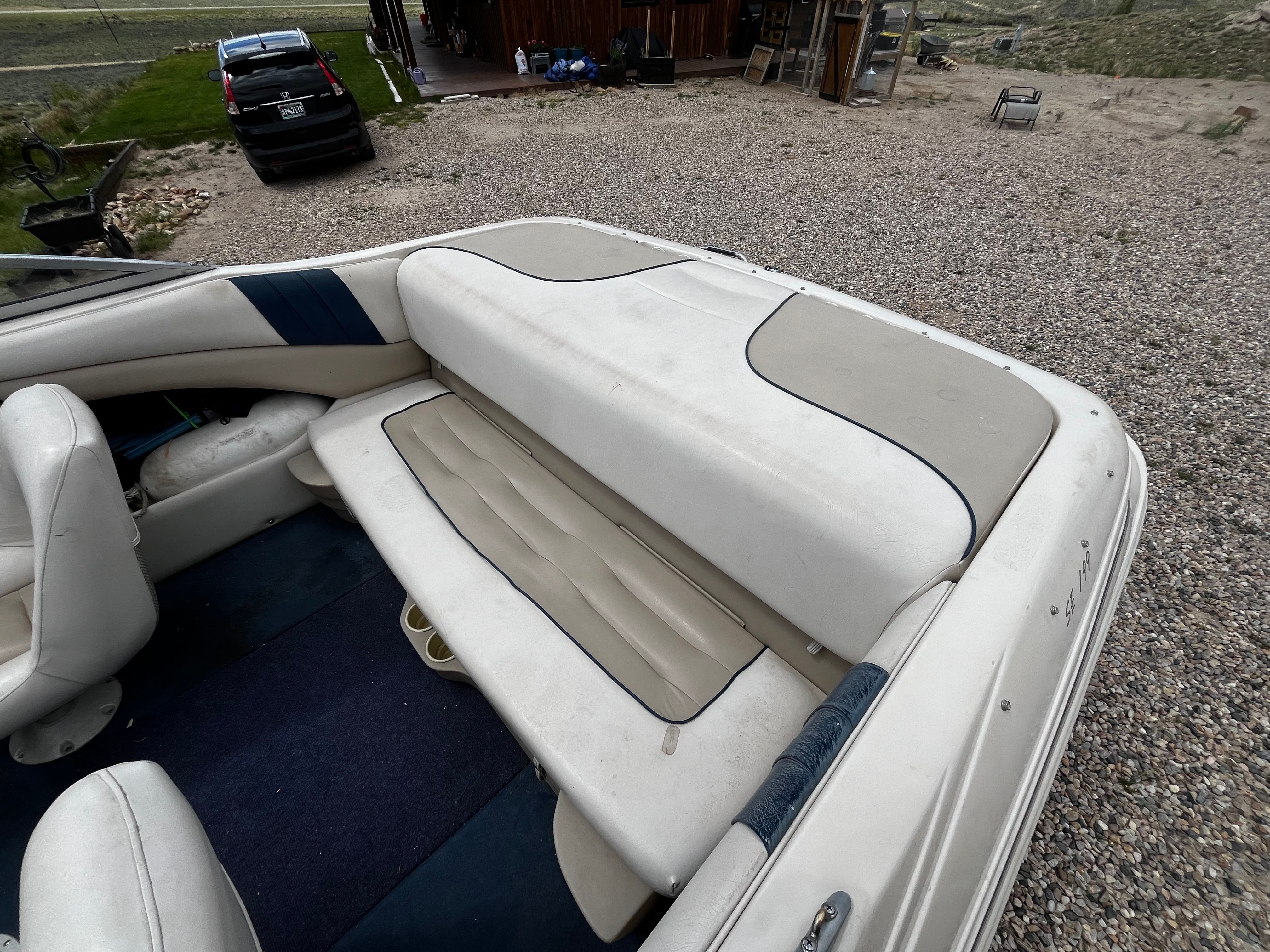 The image shows the rear of a 1998 Glastron SE199 boat with cushioned seating.