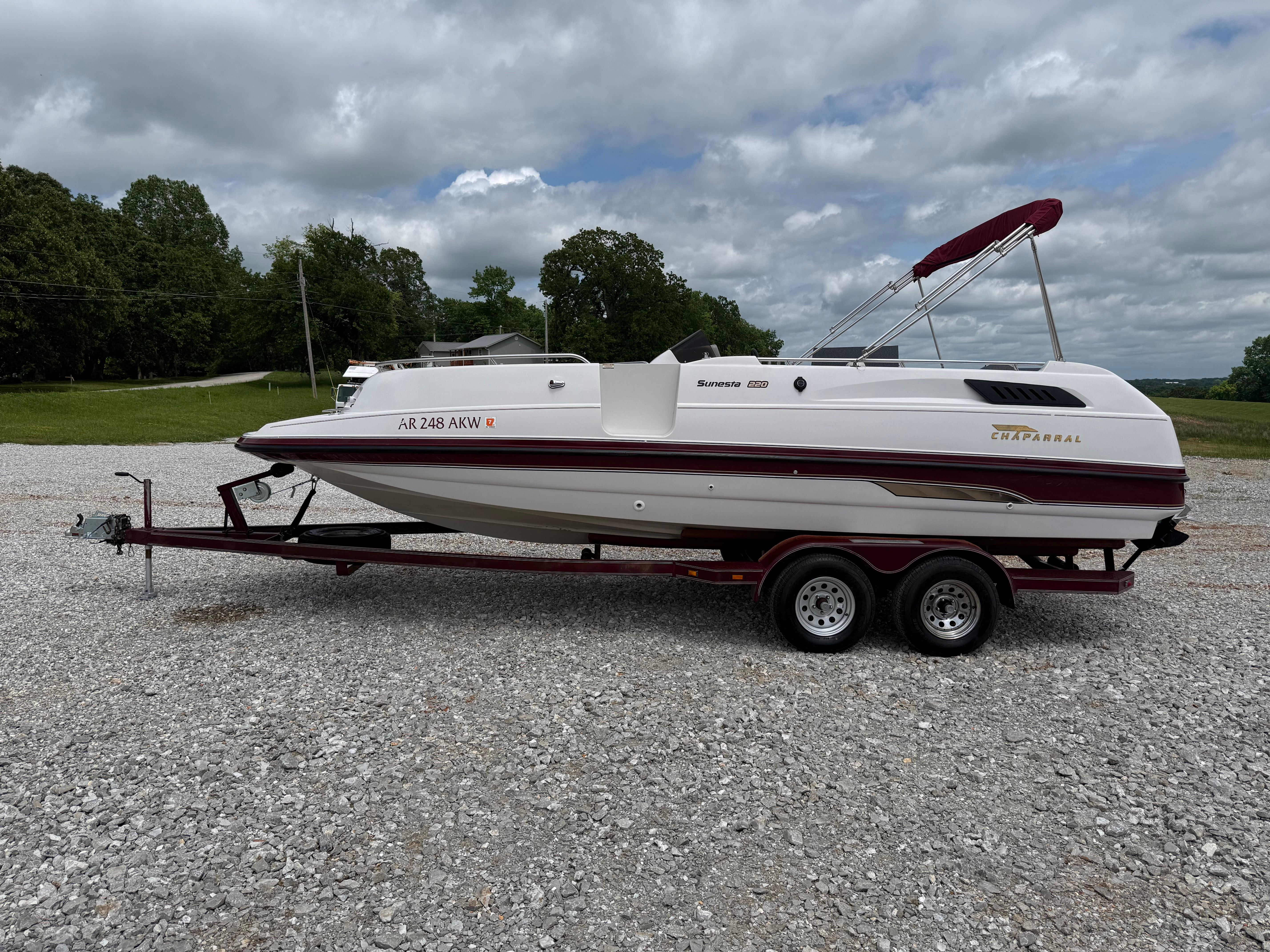 A 1994 Chaparral Sunesta 220 on a trailer, parked on a gravel lot.