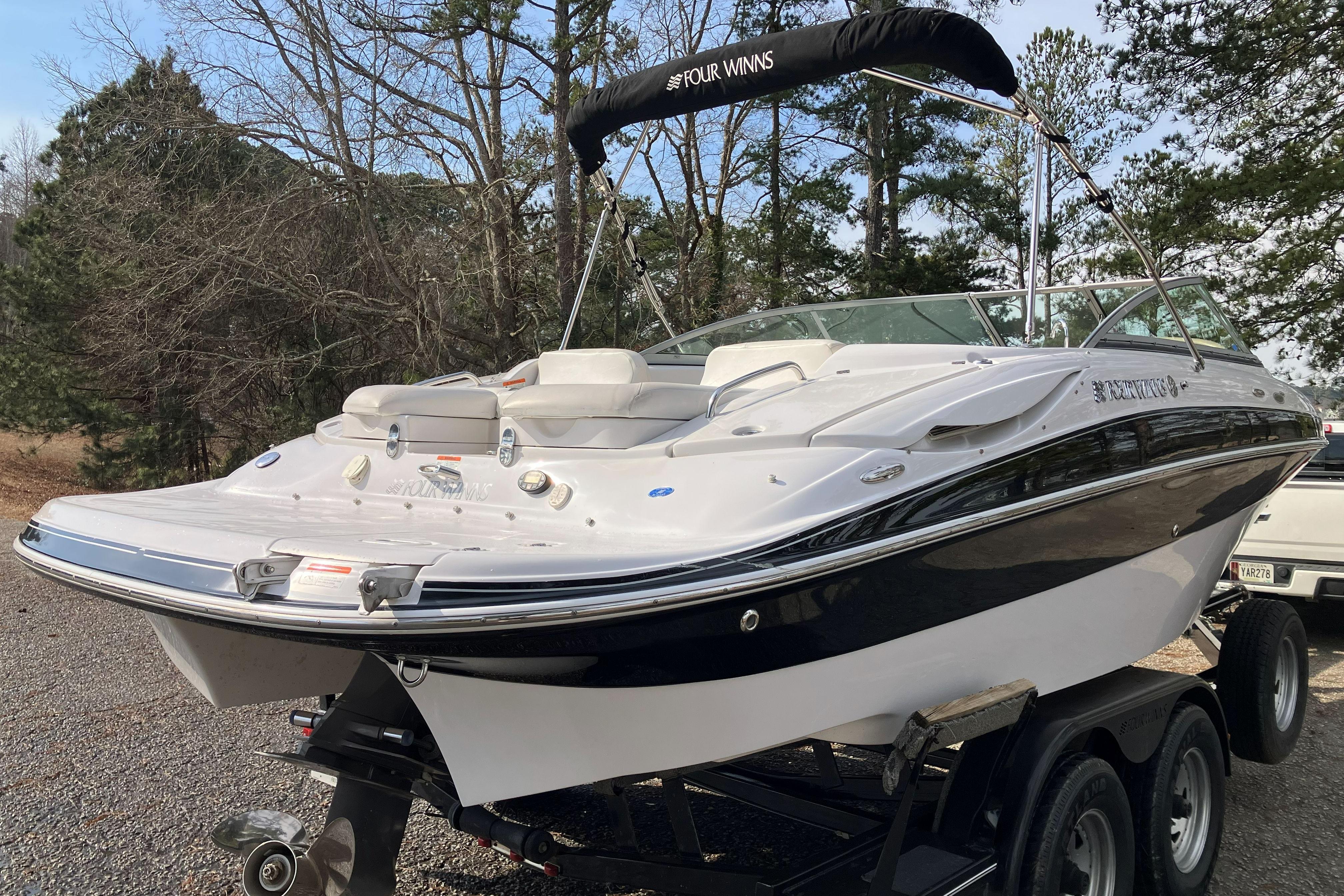 2006 Four Winns 240 Horizon boat on trailer, surrounded by trees.