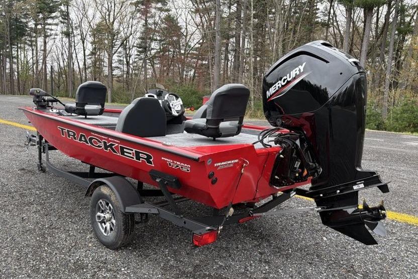 2026 Tracker Pro Team 175 boat with Mercury engine on a trailer in a wooded area.