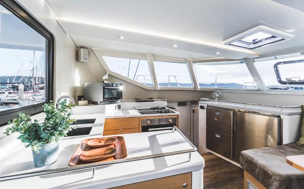 Modern yacht kitchen interior with sleek design, stainless appliances, and panoramic windows. Vision 444, 2026 model.